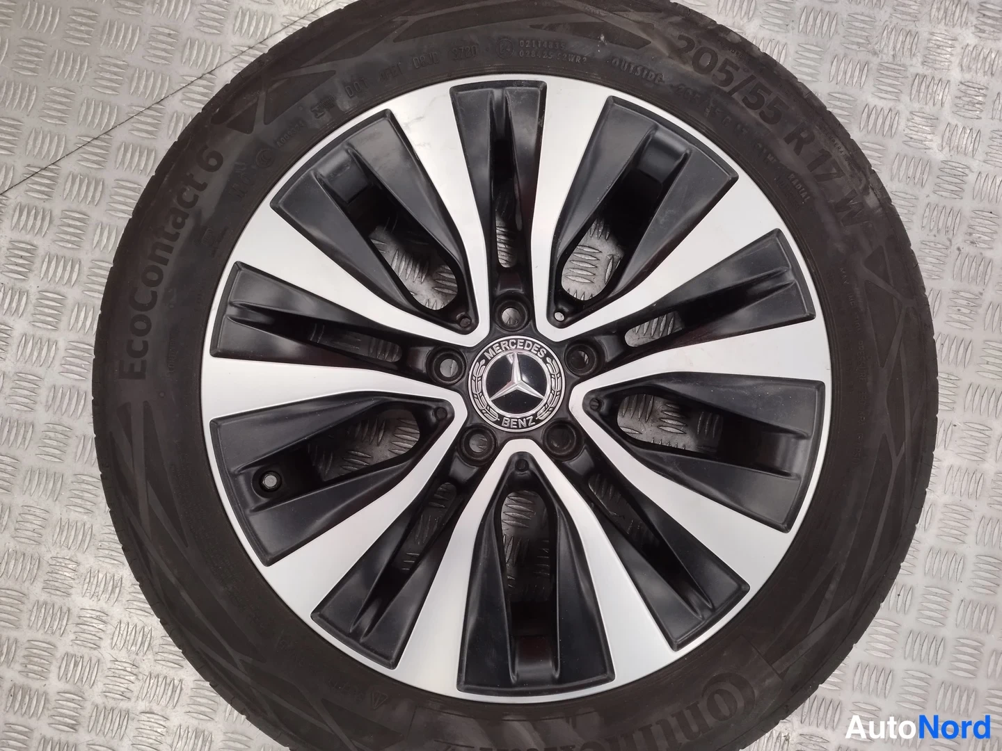 Yksityiskohta: Koko rengas ja kevytmetallivanne kuvattuna suoraan: Continental EcoContact 6 -rengas, kokomerkintä 205/55 R 17, vanneessa Mercedes-Benz-merkki.