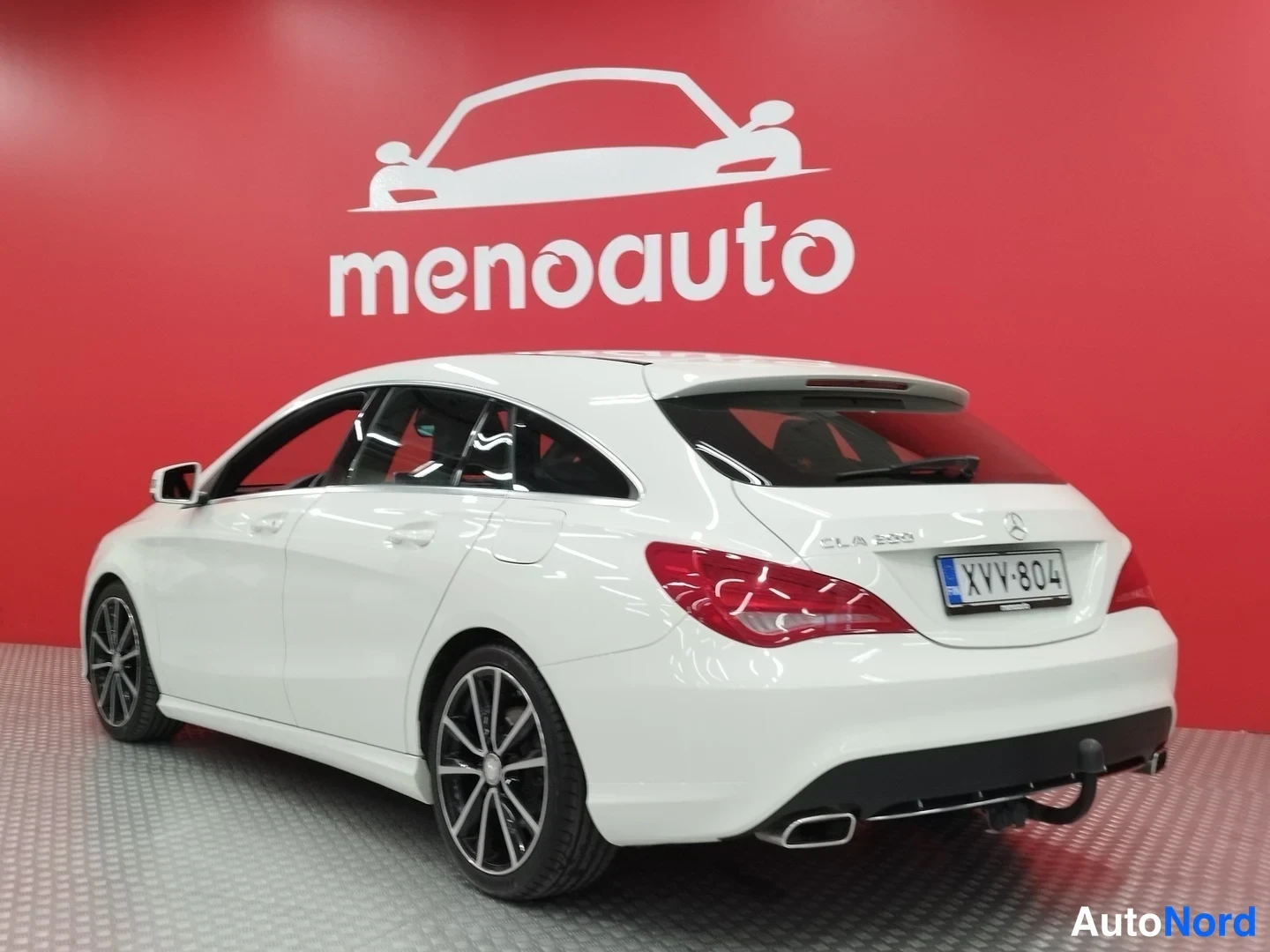 Takaviisto: Valkoinen Mercedes-Benz CLA Shooting Brake takaviistolta, rekisterikilpi, vetokoulu ja kromattu pakoputken pää näkyvissä.