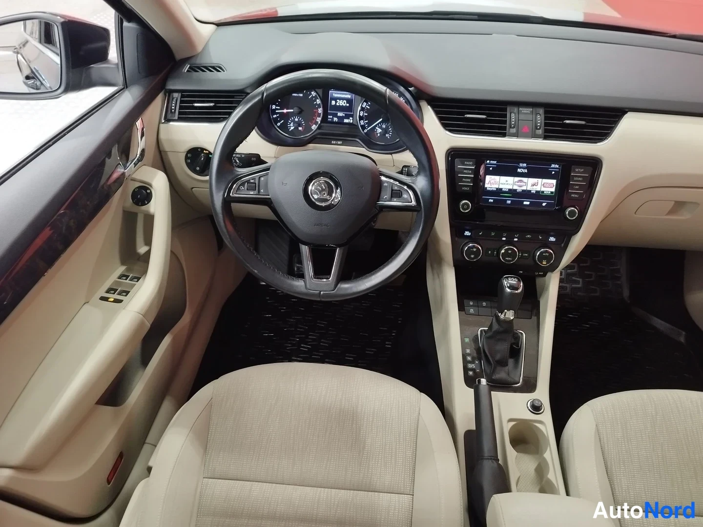 Muu: Auton ohjaamo: beige sisusta, Skoda-mittari, monitoimiohjauspyörä, kosketusnäytöllinen infotainment ja automaattivaihteen valitsin.