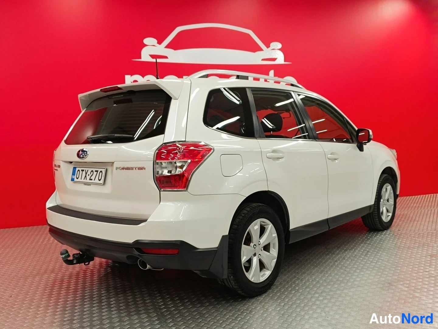 Takaviisto: Valkoinen Subaru Forester takakulmasta, rekisteritunnus ja vetokoukku näkyvissä.