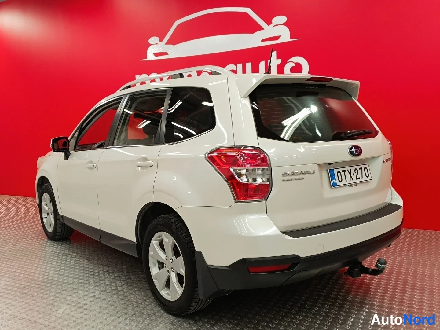Takaviisto: Valkoisen Subaru Foresterin takakulma vasemmalta taakse, takamoottoritilan kansi ja rekisterikilpi näkyvissä.