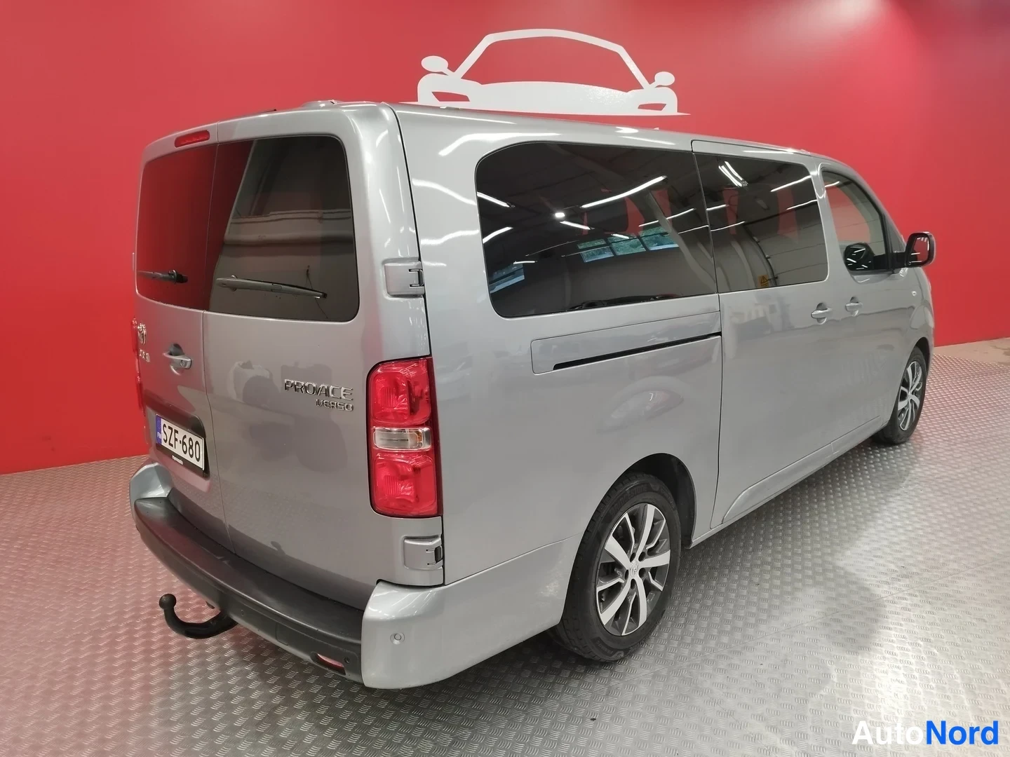 Takaviisto: Hopeaharmaa Toyota Proace Verso -pakettiauto takaa vasemmalta kolmannelta neljännekseltä, rekisteritunnus ja Proace Verso -merkintä peräovessa, sisätiloissa pun