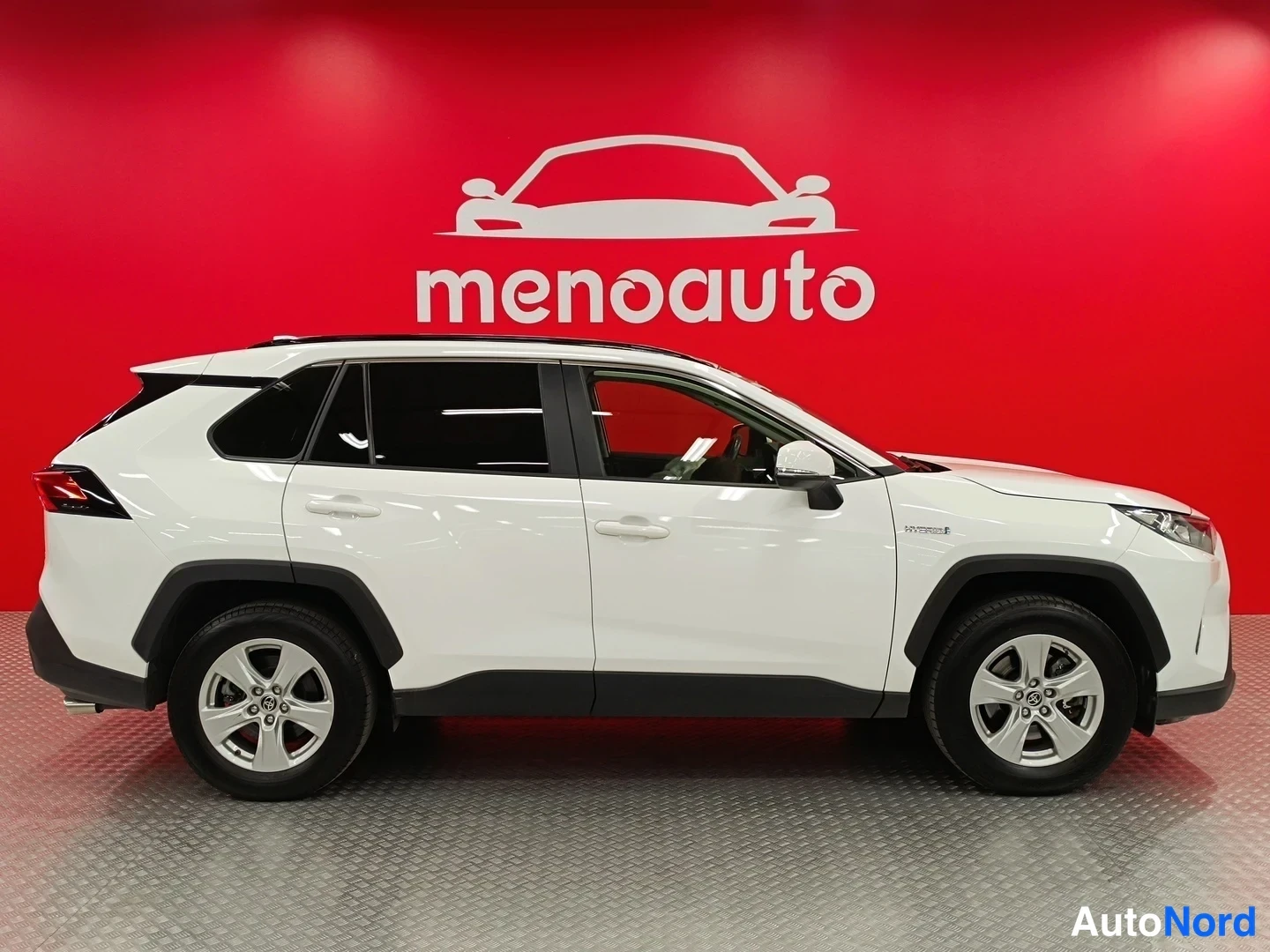 Etuviisto, nokka oikealle: Valkoinen Toyota RAV4 sivulta oikealta, ovet ja pyörät kuvattuna punaisella taustalla, ajovalo näkyy reunassa.