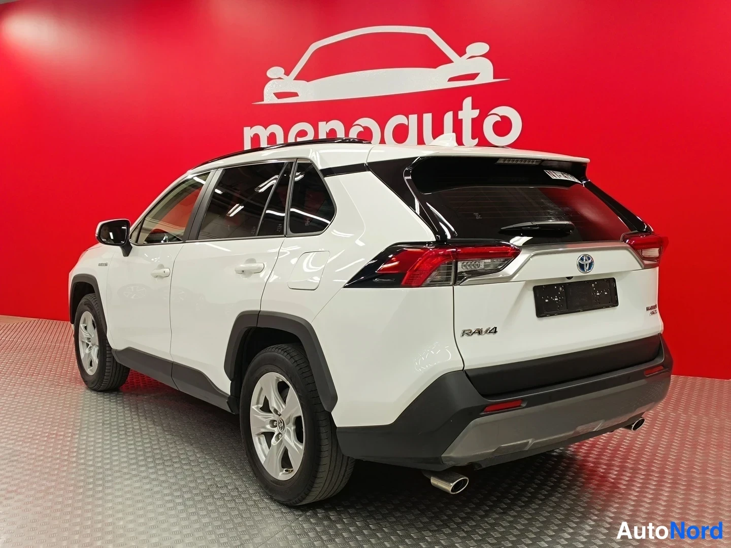 Takaviisto: Valkoisen Toyota RAV4:n takakulma punaisella taustalla; takavalot, RAV4-teksti ja Toyota-merkki näkyvät.