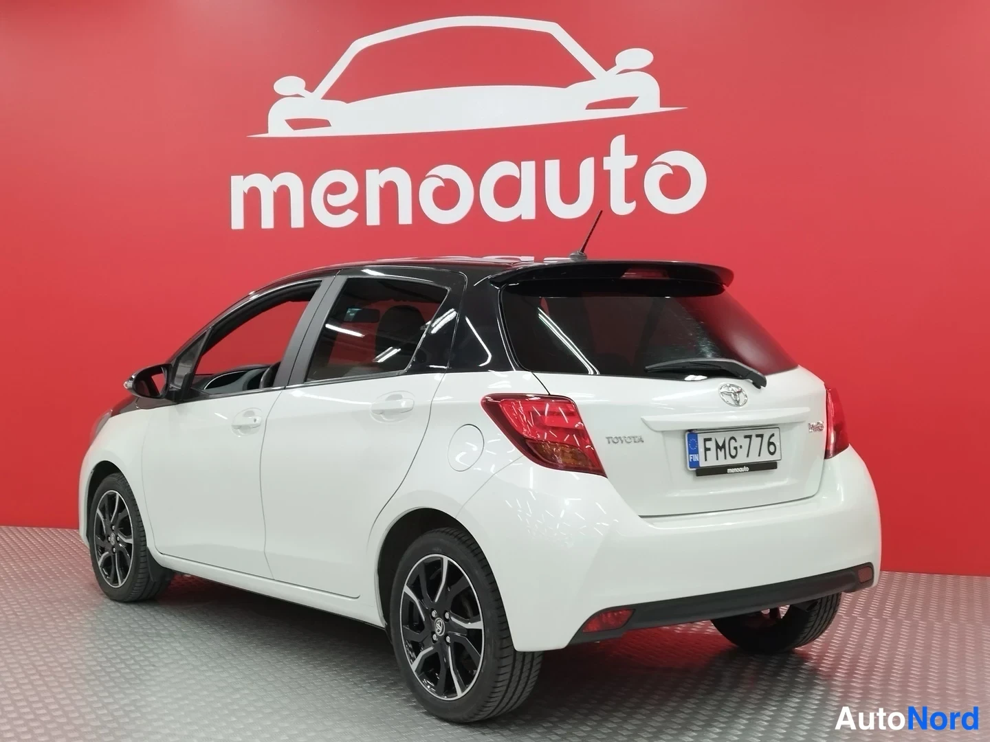 Takaviisto: Valkoisen Toyota Yaris -viistoperän takanurkka, rekisterikilpi, musta katti ja takaspoileri.