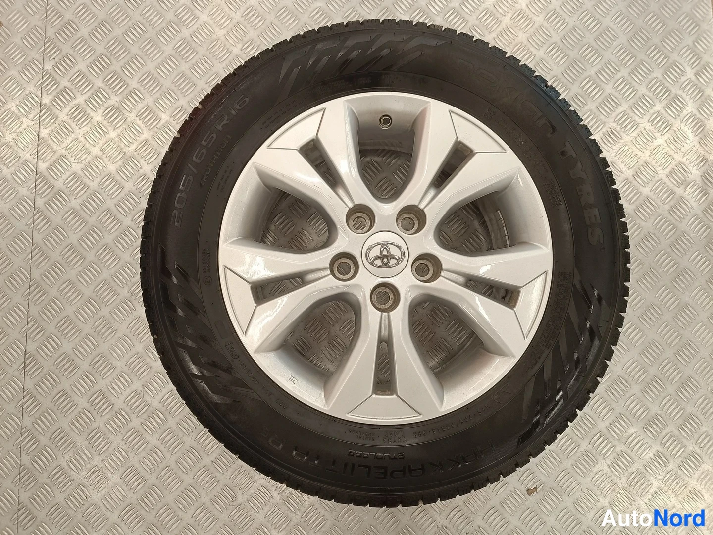 Yksityiskohta: Toyota-kevytmetallivanne kumirenkaalla, mallimerkinta 205/65 R16.