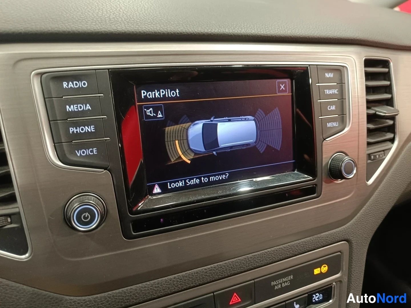 Muu: Kojeiston näyttö näyttää ParkPilot-törmäysvaroitusruudun tekstillä 'Look! Safe to move?',Radio, MEDIA, PHONE, VOICE, NAV, TRAFFIC, CAR, MENU-napit paneelissa.