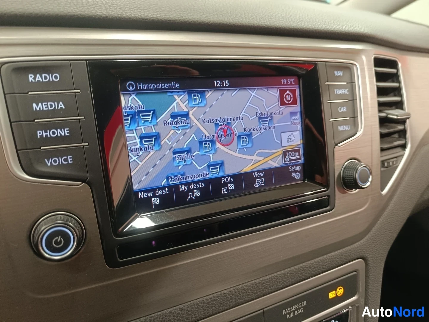 Muu: Navigointinäkymä keskinäytöllä, jossa kartta ja teksti 'Harapaisentie',Radio, MEDIA, PHONE, VOICE, NAV, TRAFFIC, CAR, MENU-napit paneelissa.