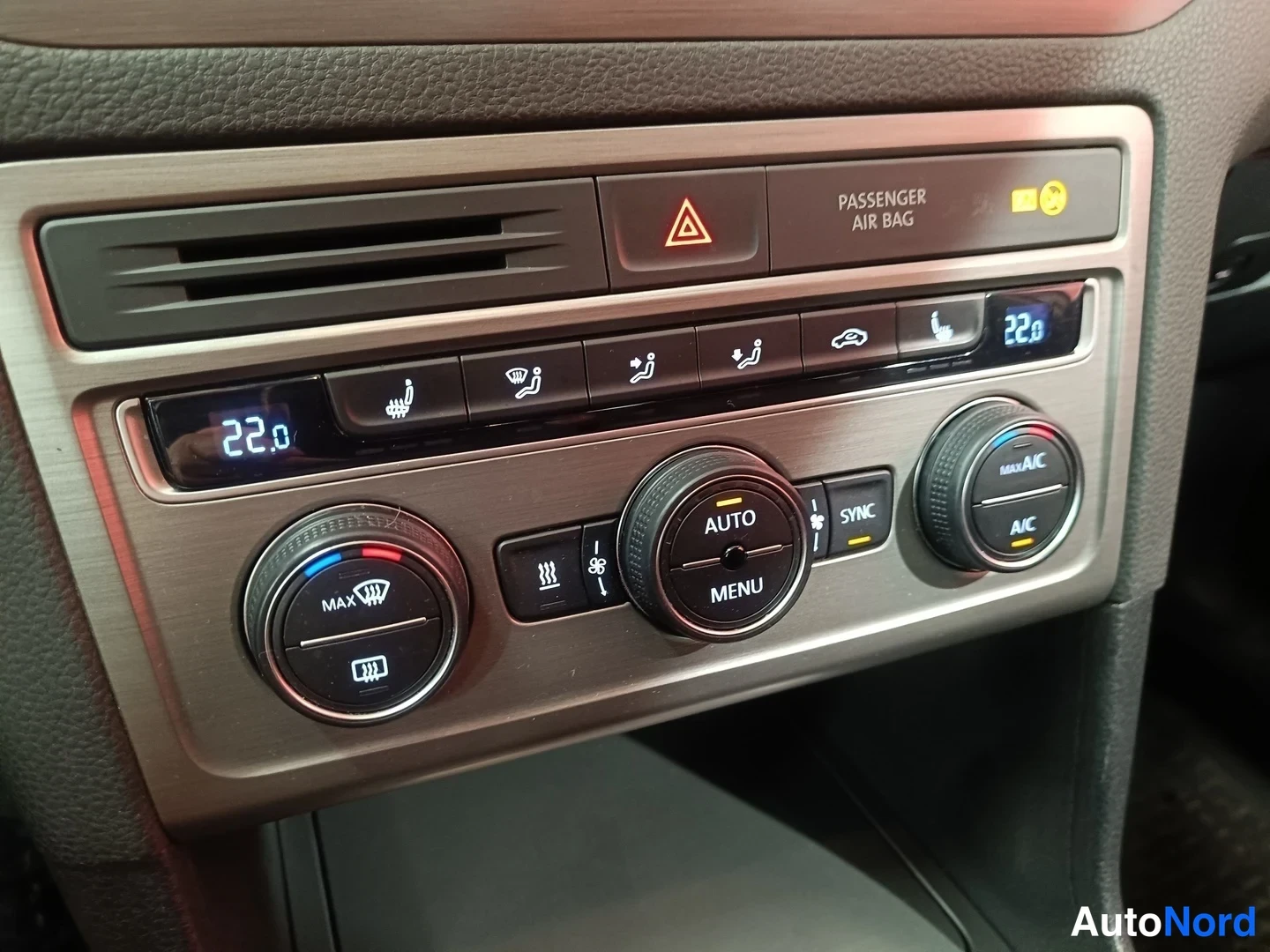 Muu: Lähikuva auton ilmastointipaneelista, A/C ja MAX AC, napit Auto, Menu, Sync, 22,0 asteen näytöt.