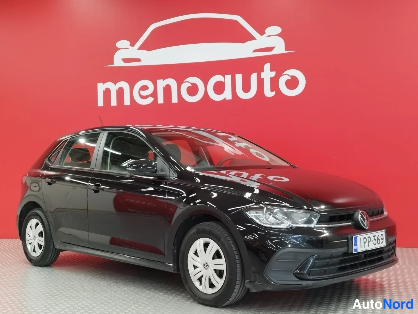 Etuviisto, nokka oikealle: Musta Volkswagen Polo viistoperä etukulmasta vasemmalle, rekisteritunnus.