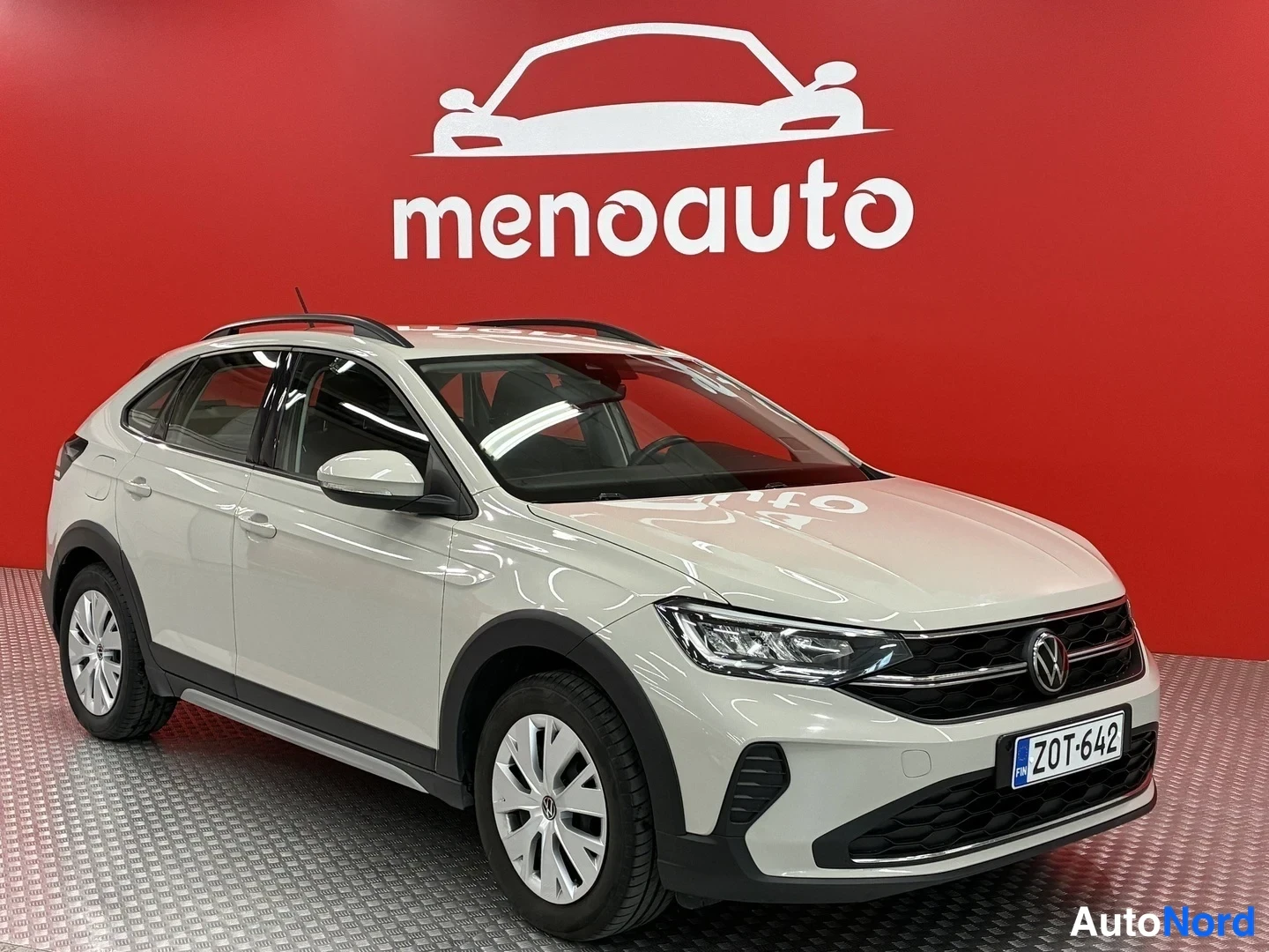 Etuviisto, nokka oikealle: Volkswagen Taigo -henkilöauto etukulmasta oikealta, vaaleanbeige runko, rekisteritunnus.