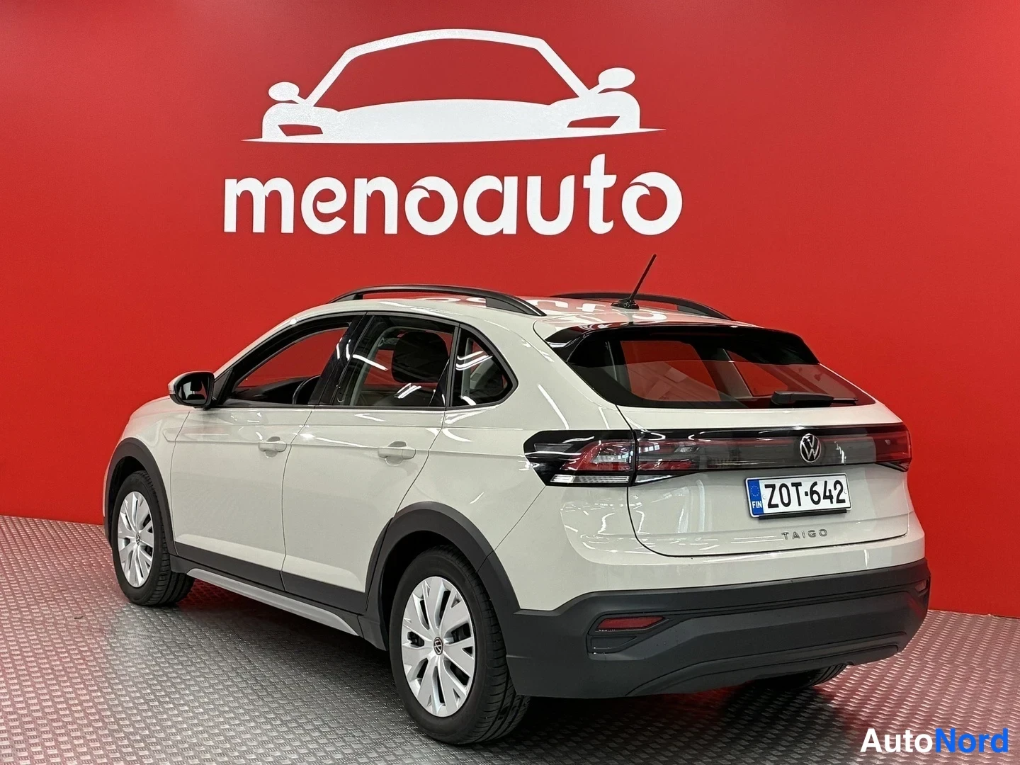 Takaviisto: Valkoisen Volkswagen Taigon takakulmanäkymä, rekisterikilpi ja Taigo-merkintä takaluukussa punaisella taustalla.
