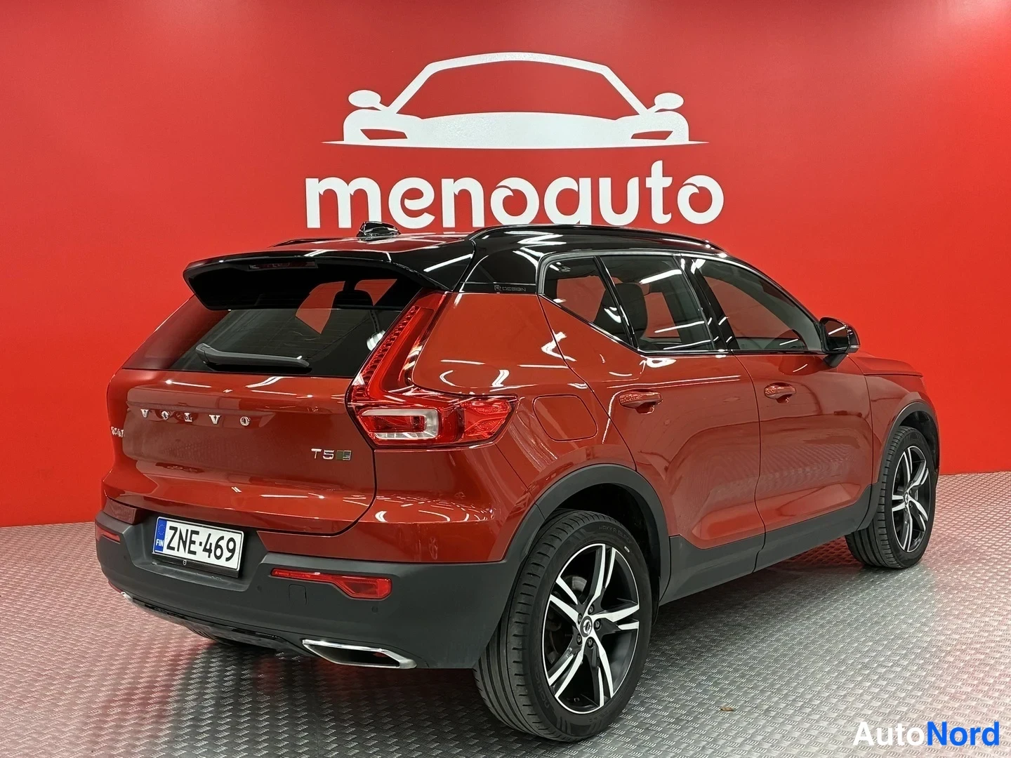 Takaviisto: Punainen Volvo XC40 takaviistosta oikealta kuvattuna, peräosassa VOLVO-teksti ja T5-merkintä, rekisteritunnus, musta katto ja kaksoispakoputki.
