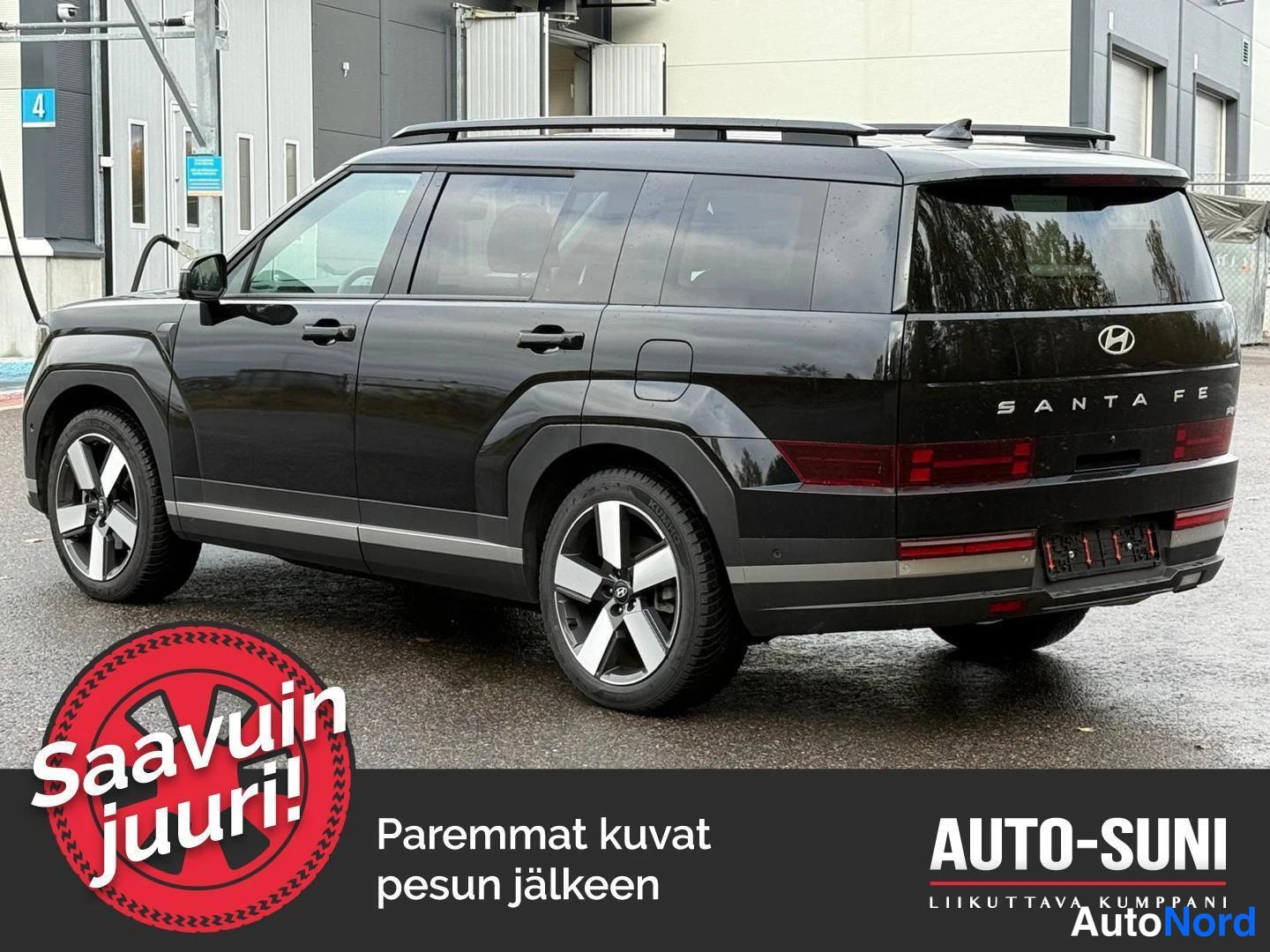 Takaviisto: Mustan maastoauton takakulmaku vasemmalta; kylki ja takaosa näkyvissä, boot-lidilla SANTA FE -teksti.