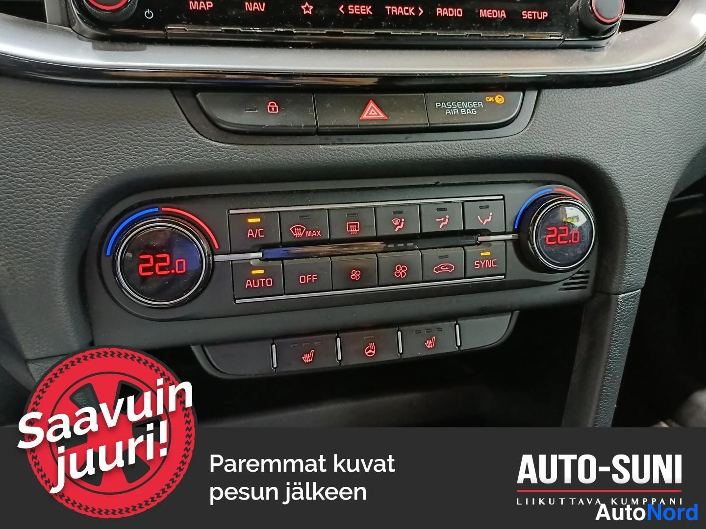 Muu: Kojetason ilmastointipaneeli kahdella säätörullalla, molemmissa 22,0 astetta, näppäimillä A/C, AUTO, OFF ja SYNC, auton sisätiloissa.