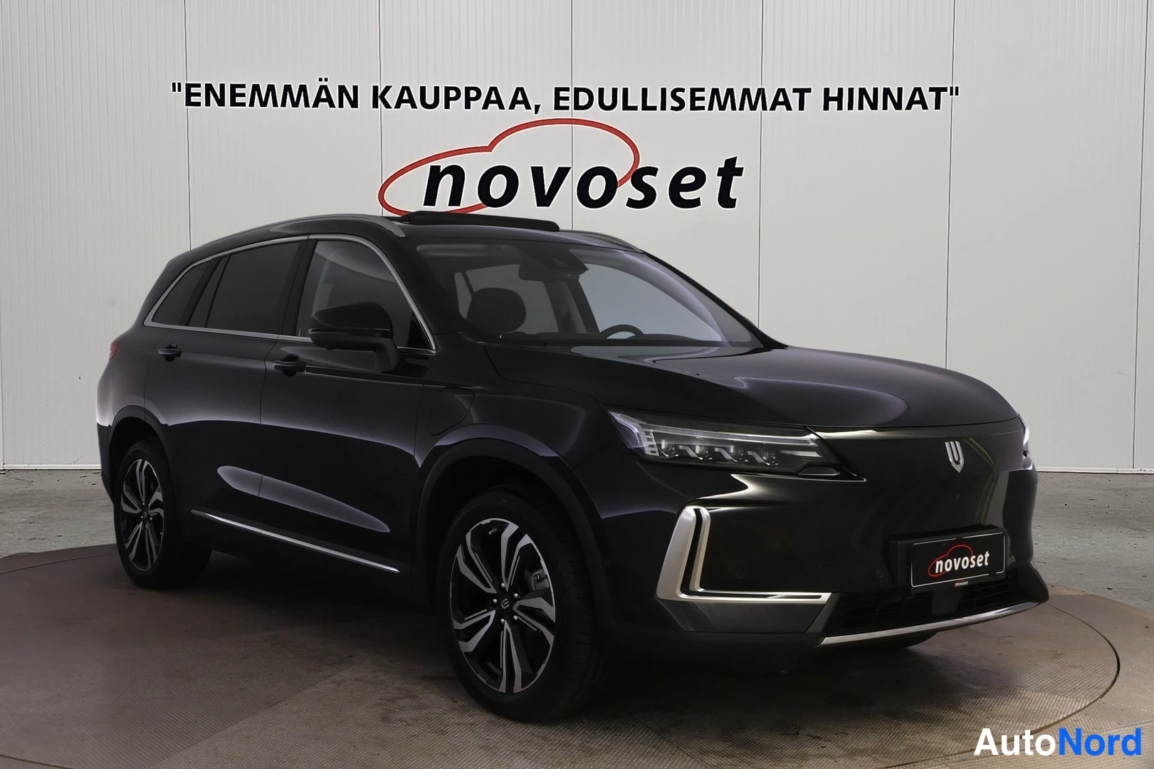Etuviisto, nokka oikealle: Musta Skywell Beckham -maastoauto kolmanneltakulmasta edestä oikealta, studio­taustassa novoset-logo.