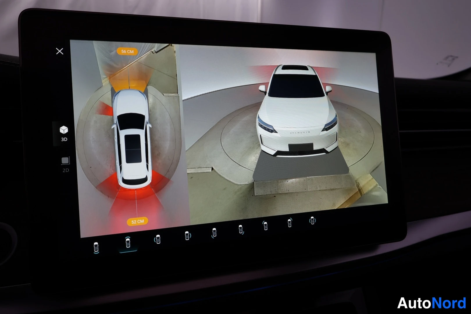 Muu: Auton infotainment-näytöllä 360 asteen ympäristökameranäkymä, jossa valkoinen auto kuvattuna ylhäältä ja edestä, etäisyysmerkinnät 56 cm ja 52 cm.