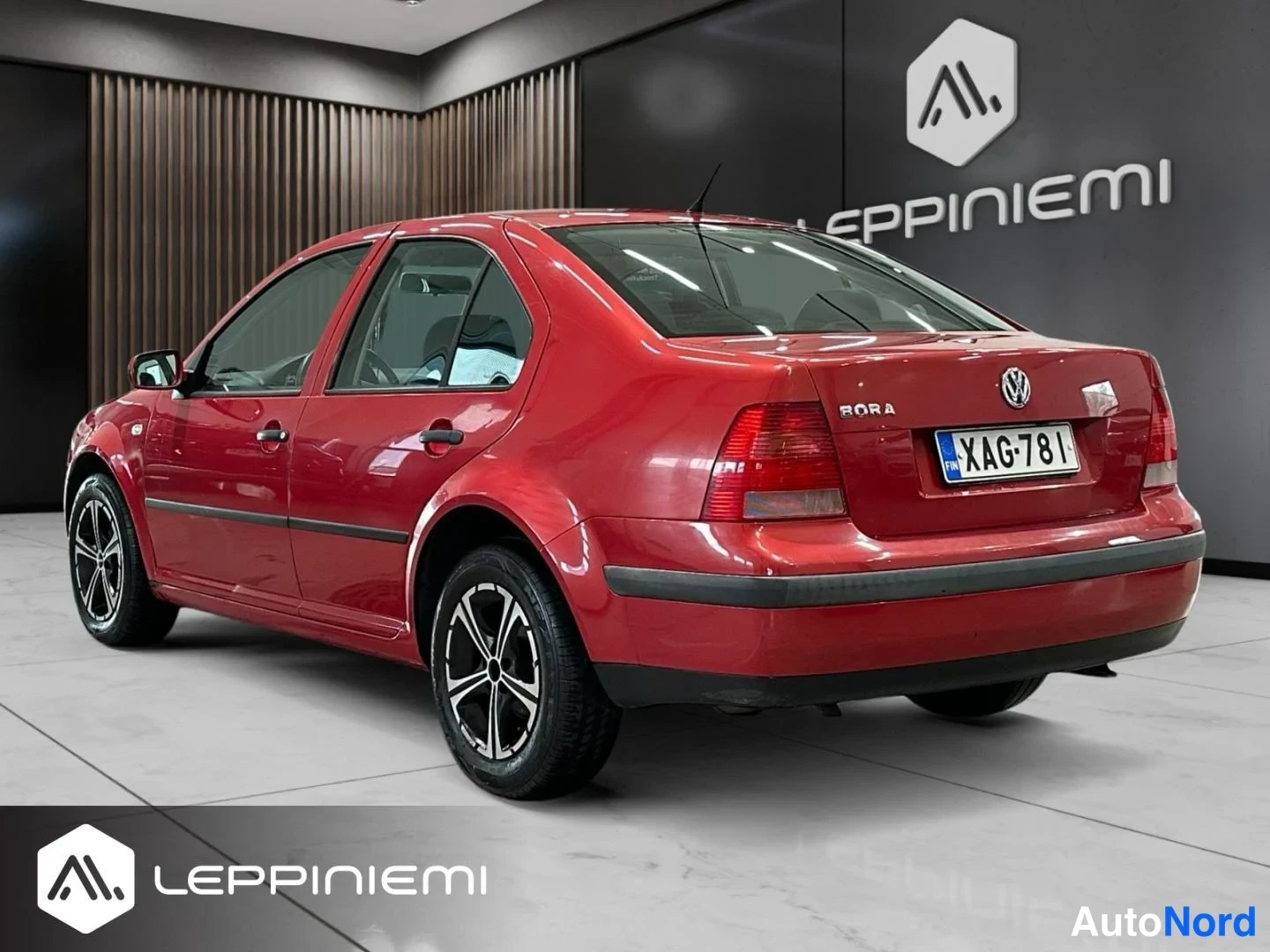 Takaviisto: Punainen Volkswagen Bora -sedanin takakulmanäku, rekisteritunnus.