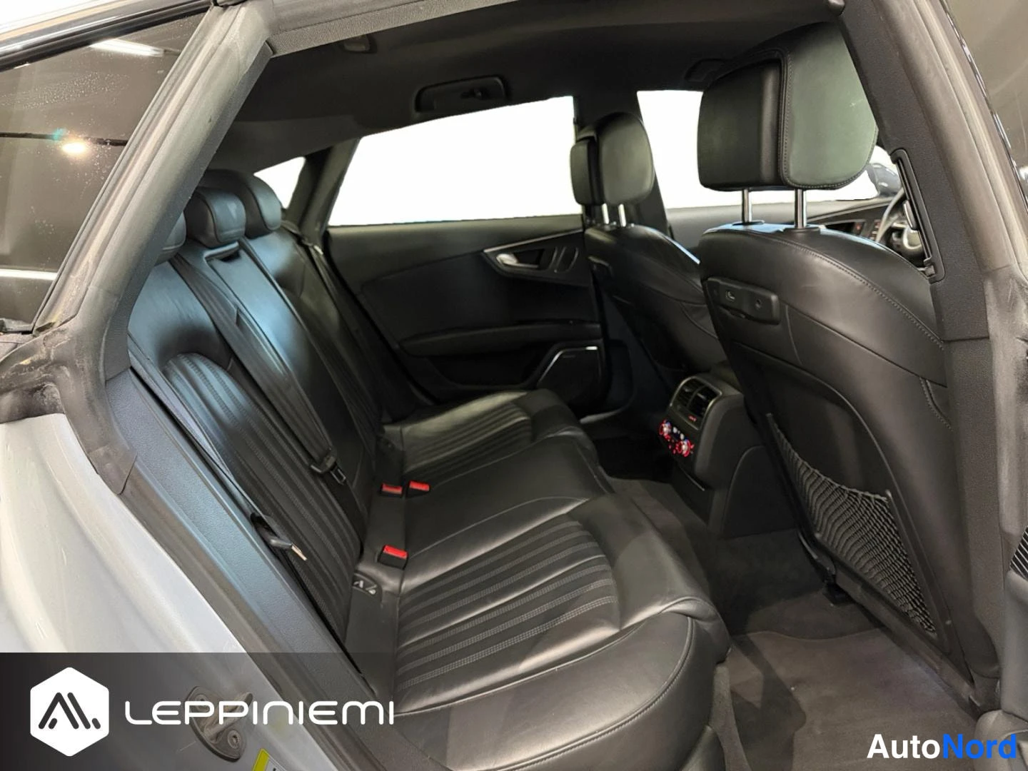 Muu: Takaohjaamon näkymä Audi A7:ssä: takaistuin, turvavyöt ja lokerot ovat näkyvissä auton sisätiloissa.
