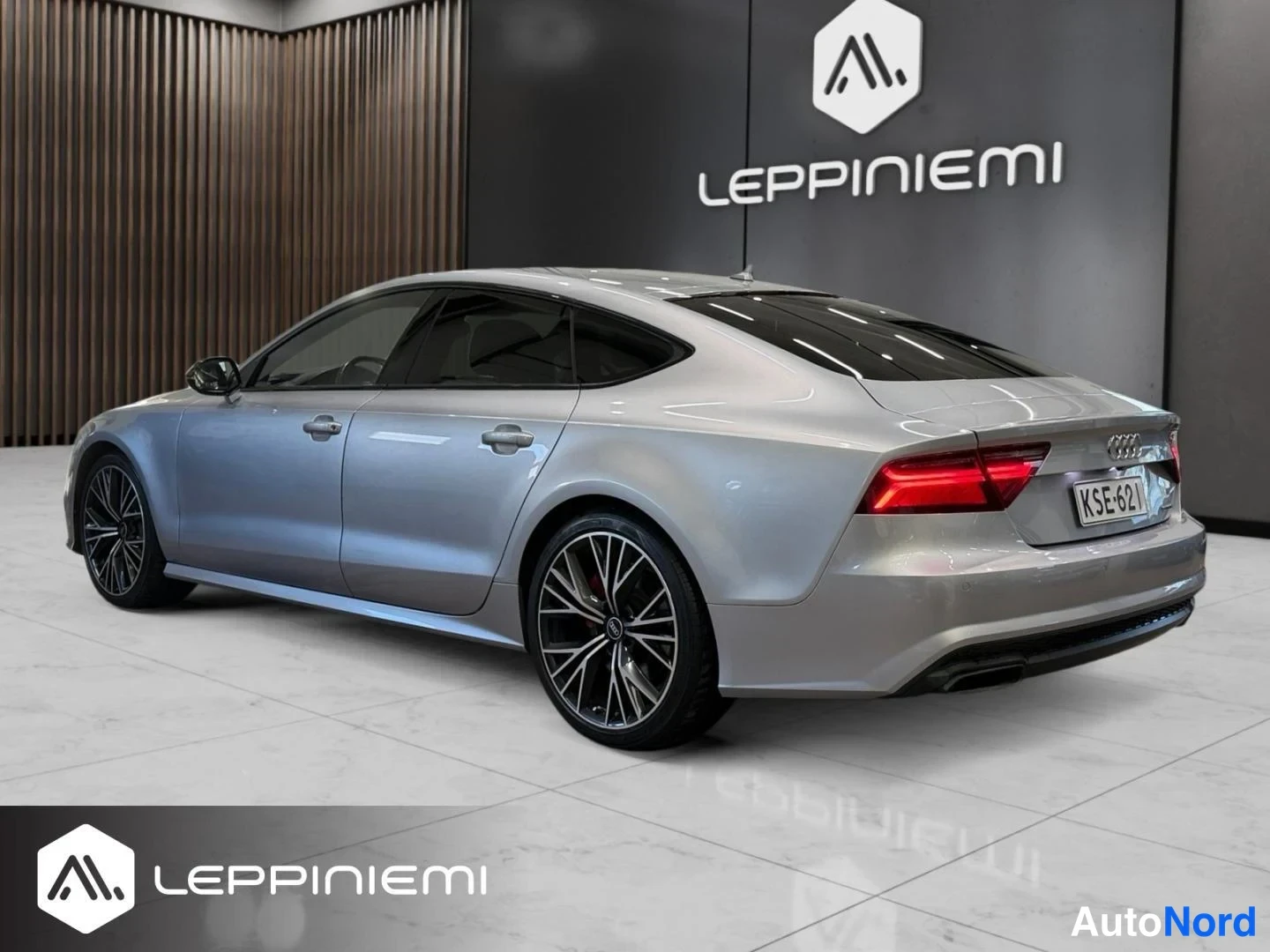 Takaviisto: Hopeanvärinen Audi A7 Sportback takaa sivulta kuvattuna, -rekisterikilpi näkyvissä.