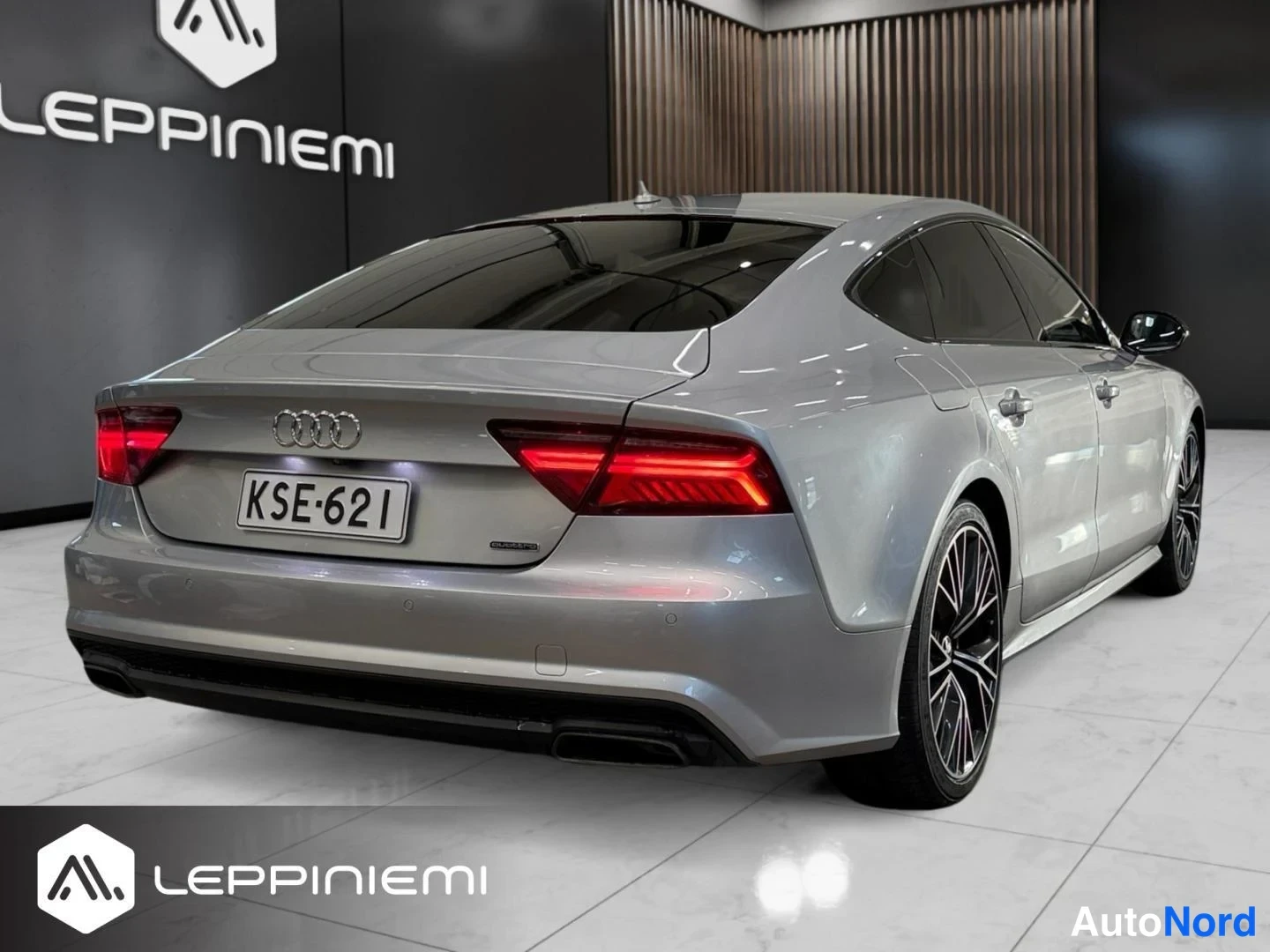 Takaviisto: Hopeanvärinen Audi A7 Sportback takaa toiselta sivulta kuvattuna, -rekisterikilpi näkyvissä.