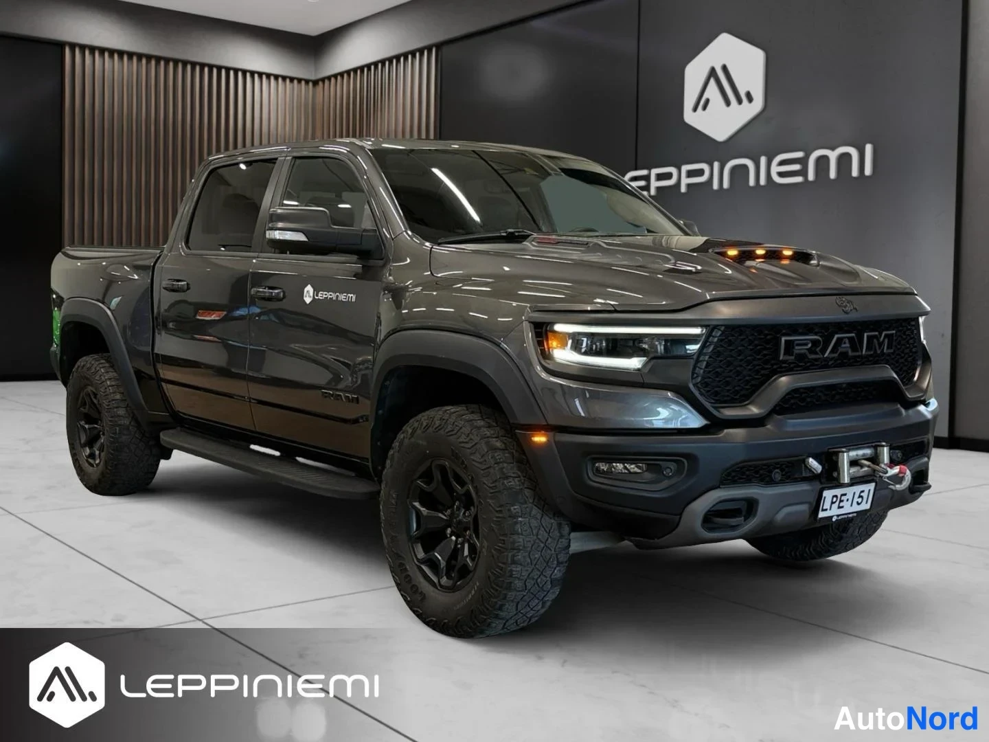 Etuviisto, nokka oikealle: Tummanharmaa pickup-neliveto auto näkyvissä etukulmasta oikealta, kylki ja keula kuvassa, mustat vanteet ja off-road-renkaat.