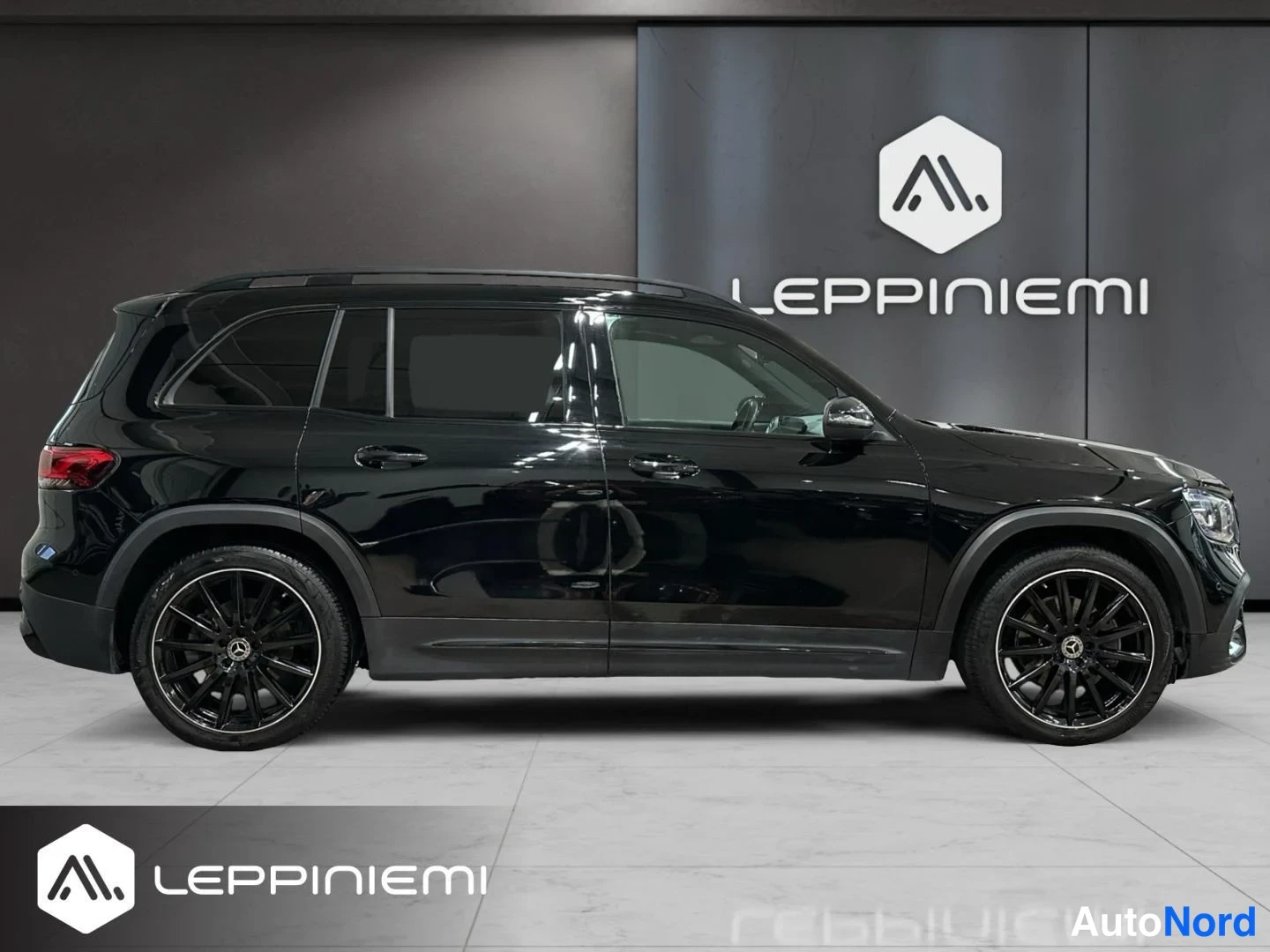 Sivulta: Mustan Mercedes-Benz GLB:n sivunäkymä oikealta puolelta sisätiloissa.
