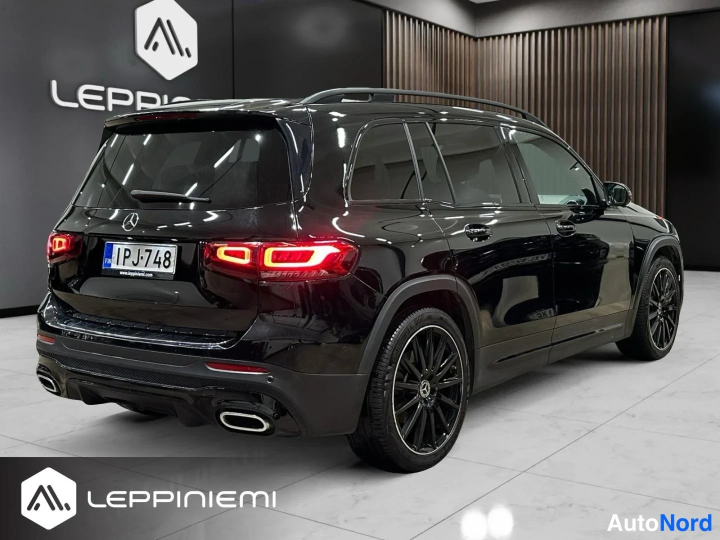 Takaviisto: Musta Mercedes-Benz GLB takakulmasta, rekisteritunnus, LED-takavalot ja mustat kevytmetallivanteet näkyvissä sisätiloissa.