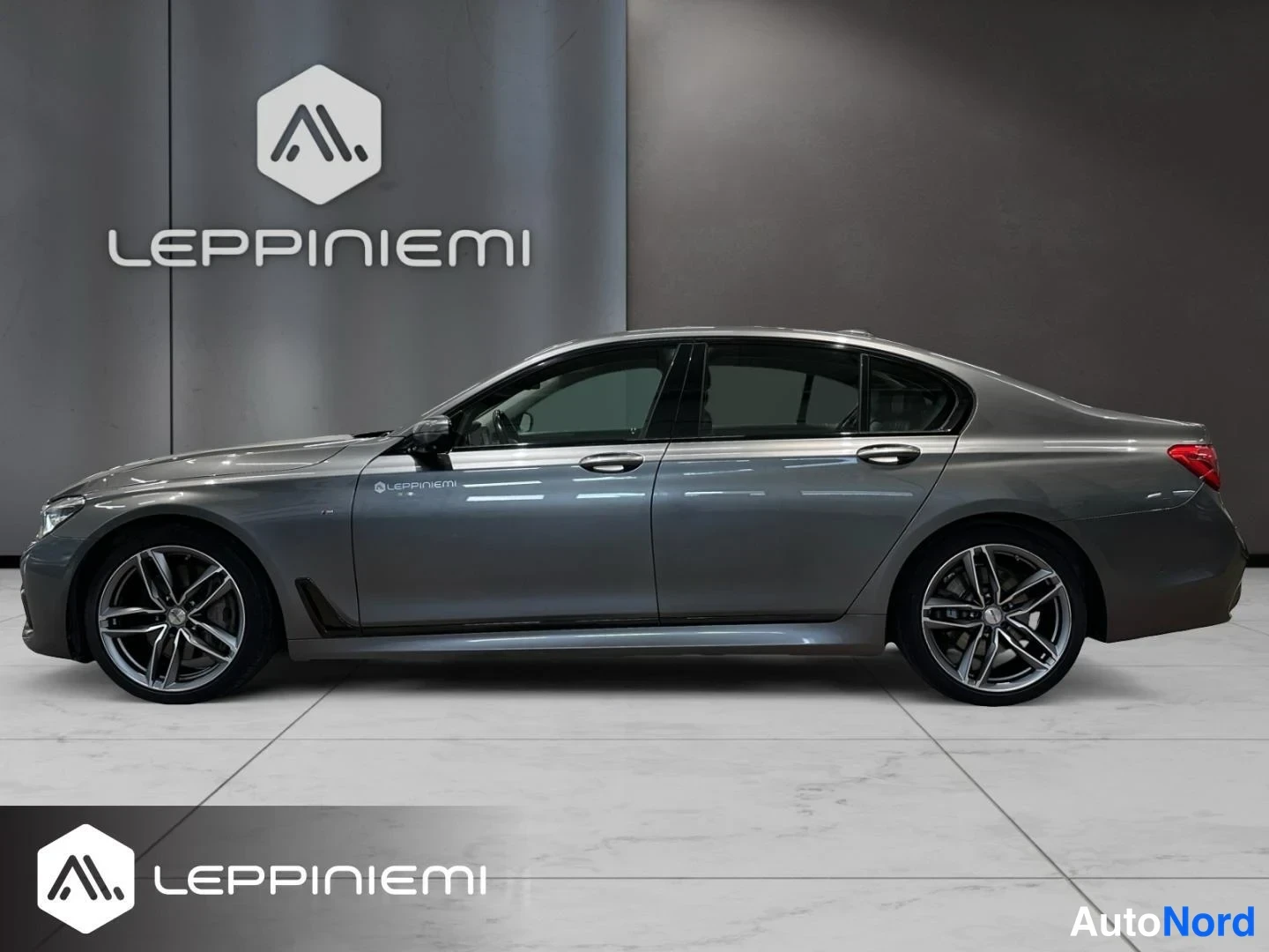 Sivulta: BMW 7-sarjan sedanin sivuprofiili, vasen kylki, showroom-tila