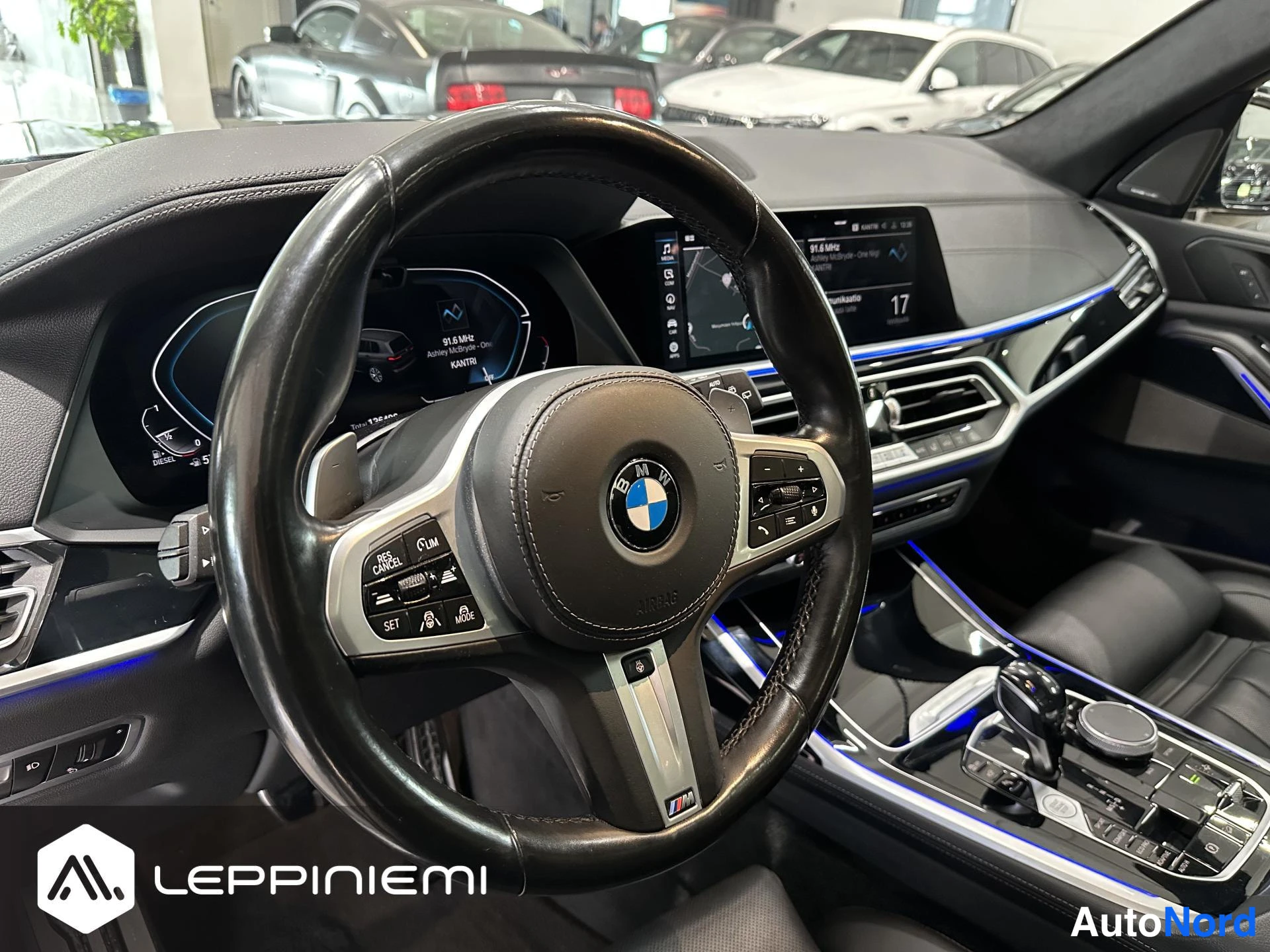 Etuviisto, nokka oikealle: Ohjaamo BMW-merkillä: M-merkkinen ohjauspyörä, digitaalinen mittaristo, keskikäyttöpaneeli ja kosketusnäyttö, tummat nahkaistuimet ja sininen ympäristöva