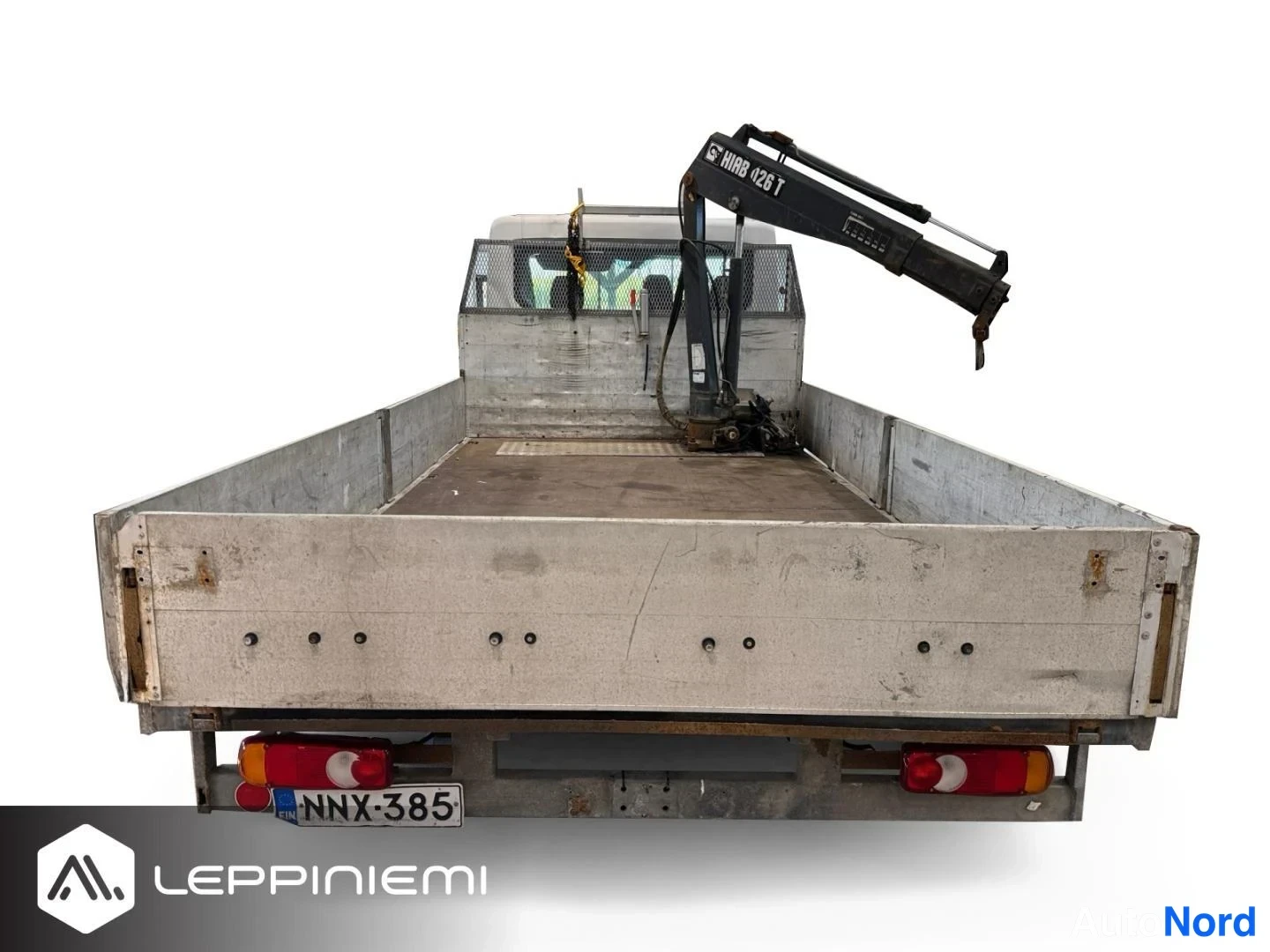 Takaa: Avolavan takaosan suora näkymä; perävaunun metalliset sivulaudat ja HIAB 026 T -kuormainnosturi, takavalot ja rekisterikilpi näkyvät.