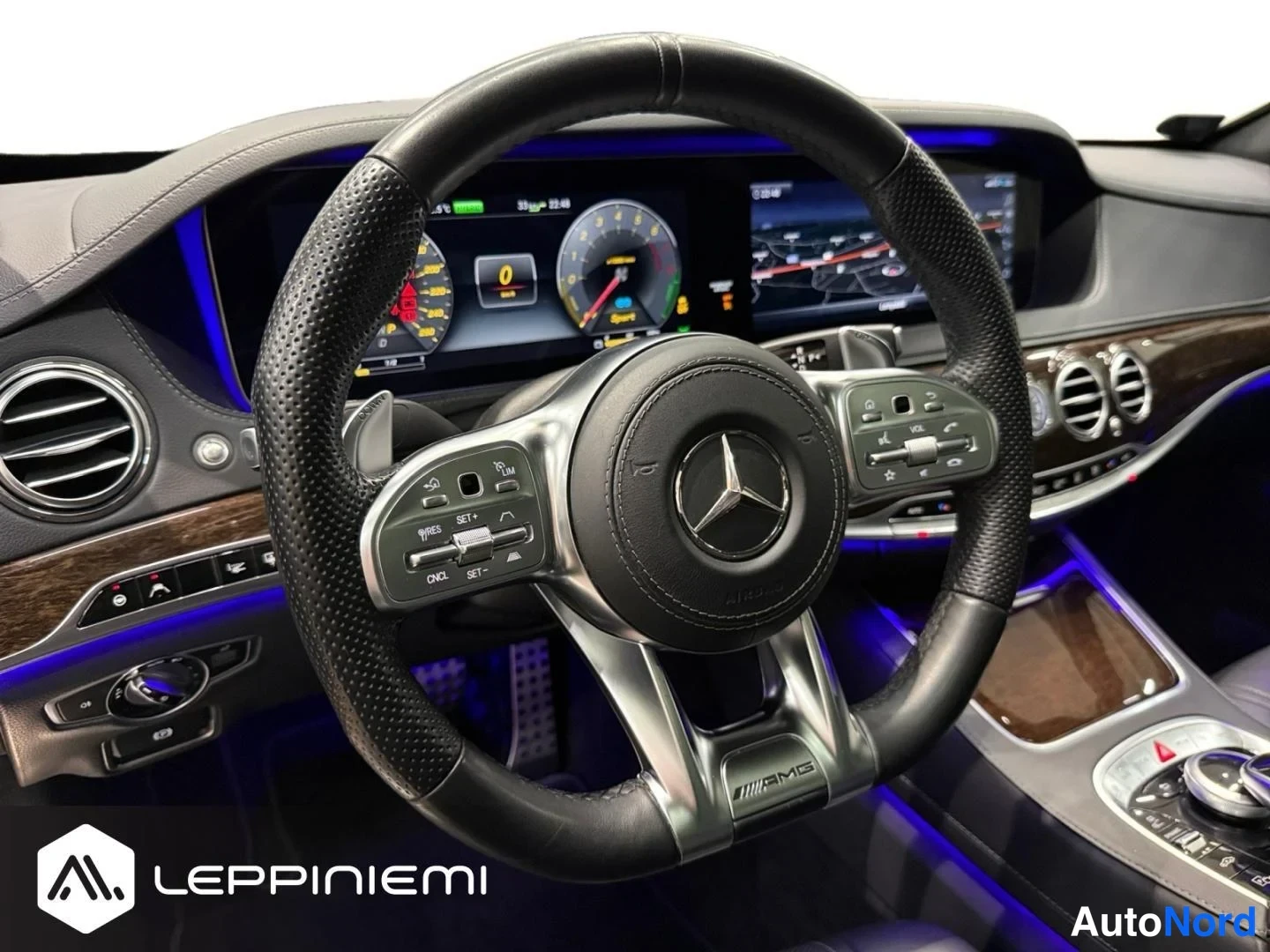 Muu: Ohjaamon näkymä: Mercedes-AMG-merkkinen nahkakulmaisympyrä, digitaalinen kahden näytön kojelauta, puukoristeet ja sininen tunnelmavalaistus.