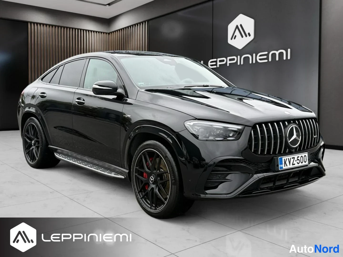 Etuviisto, nokka oikealle: Musta Mercedes-Benz GLE Coupé etuviistereunalta oikealta, AMG-ritilä ja punaiset jarrusatulat näkyvät.