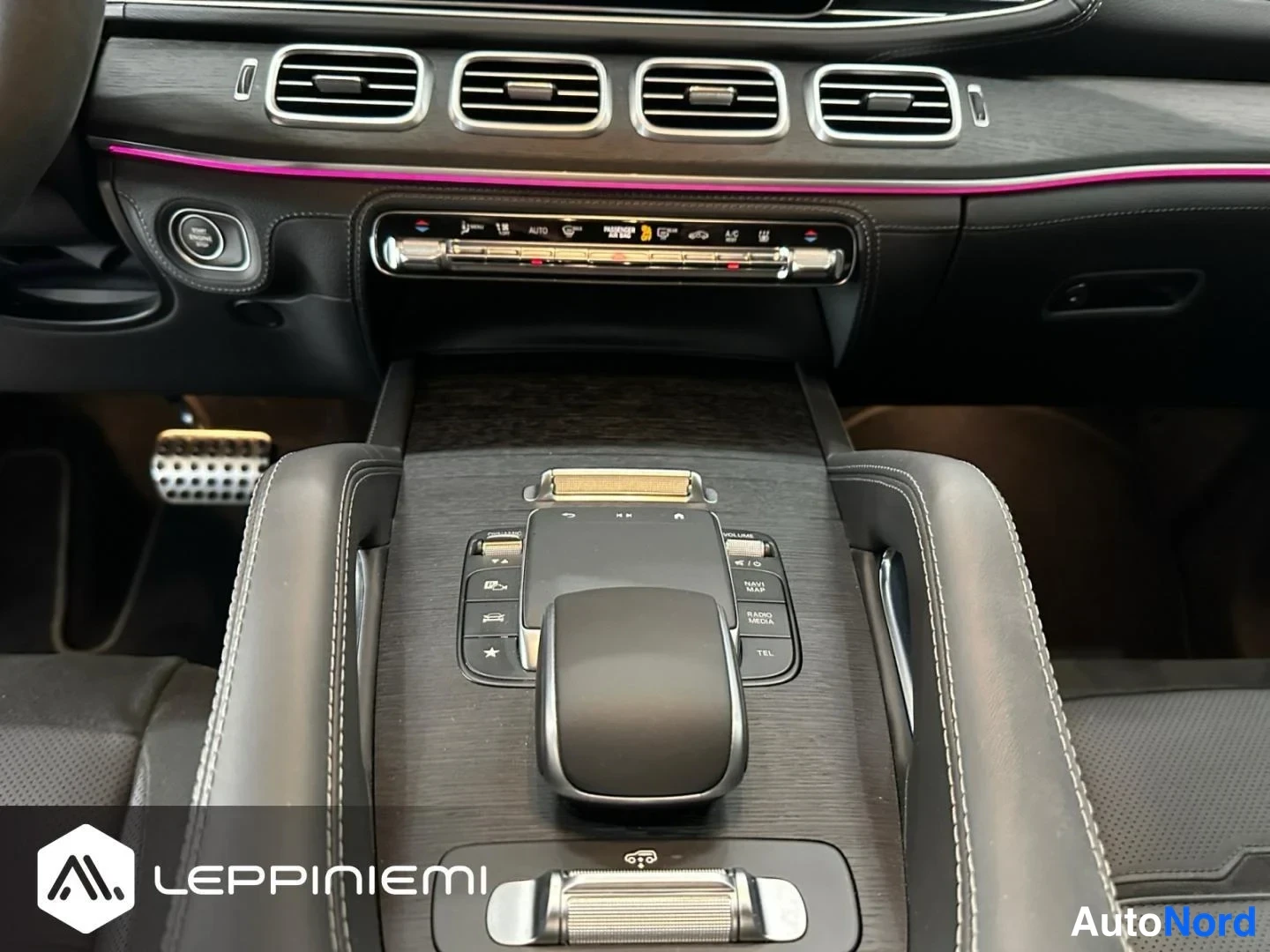 Muu: Mercedes-Benzin kojetaulun ja keskitunnelin lähikuva: ilmastointiautoin, tunnelmavalaistus, touchpad-ajokontrolli ja radio/navigointipainikkeet, musta sisusta j