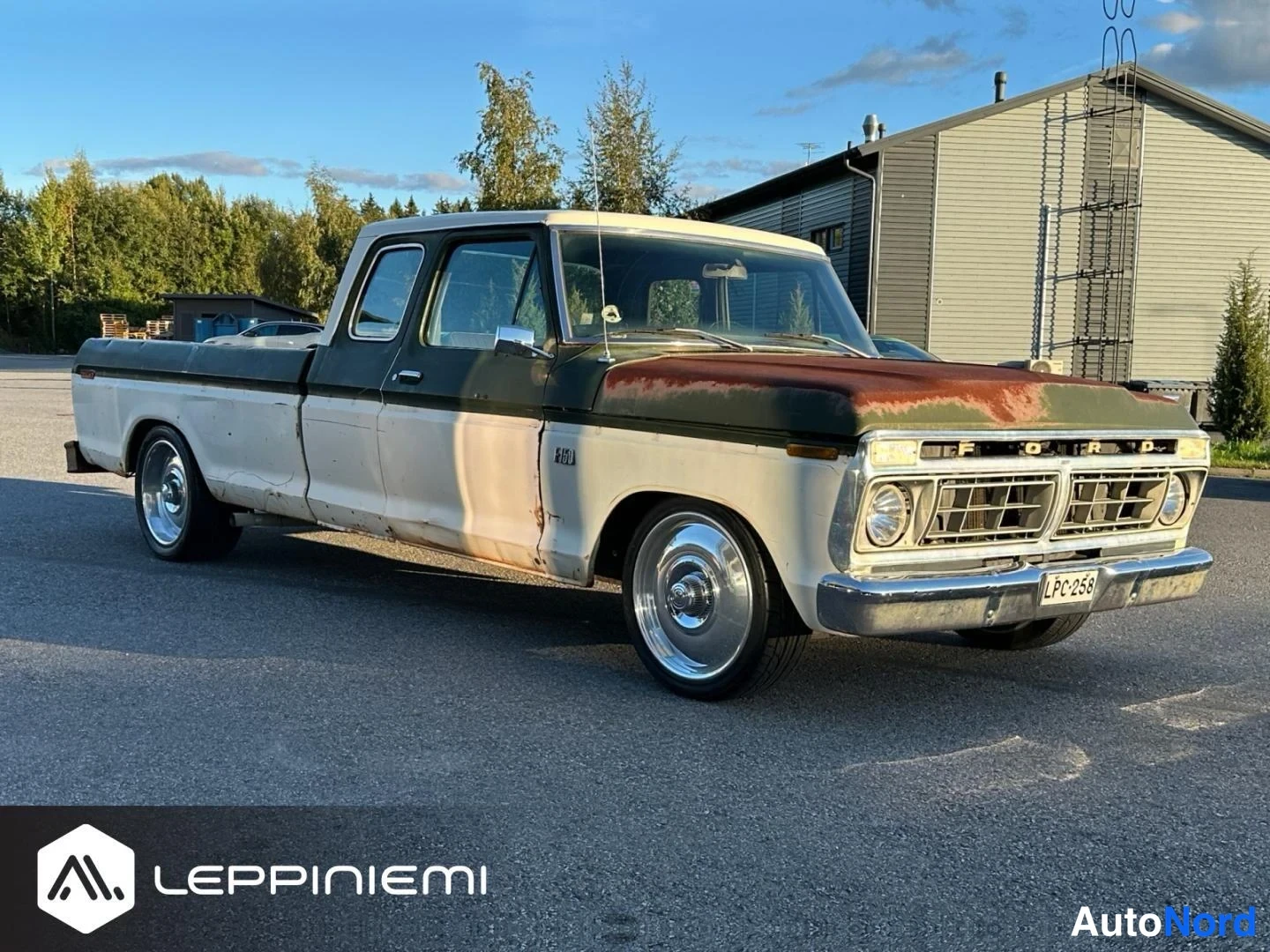Etuviisto, nokka oikealle: Vanha avolava-auto etukulmassa oikealle: potkuriin ja etusäleikköön FORD, rekisterikilpi, koppipelti runsaasti ruostetta.