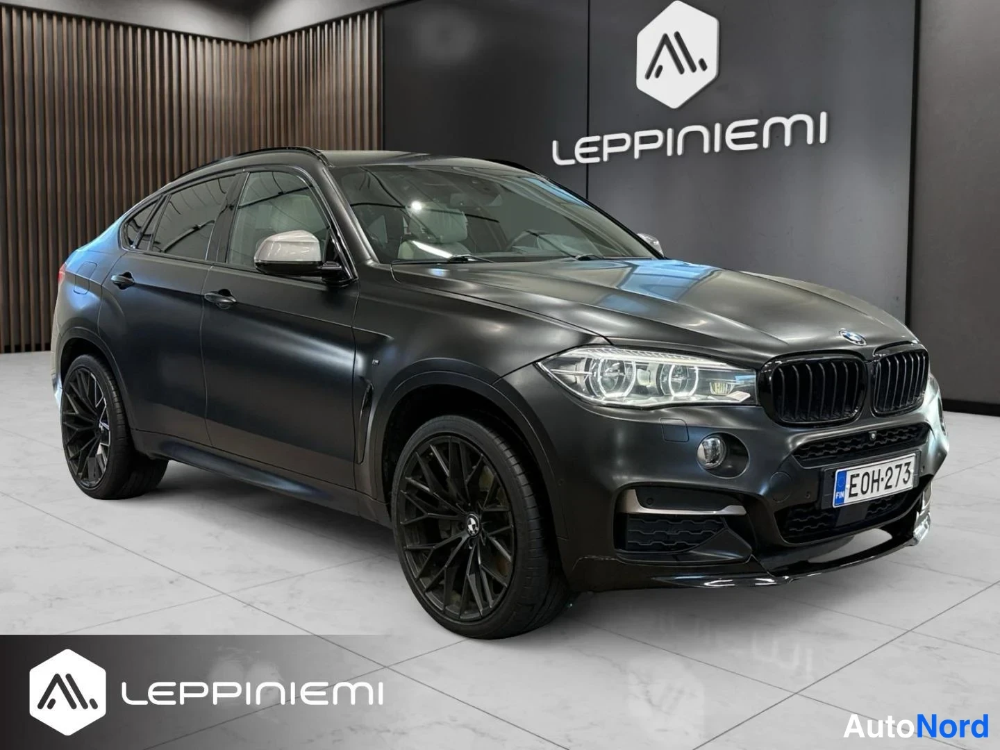 Etuviisto, nokka oikealle: Musta BMW X6 kulmaan kuvattuna edestä oikealta, record-levyisät kevytmetallivanteet ja rekisterikilpi E0H-273 näkyvät.