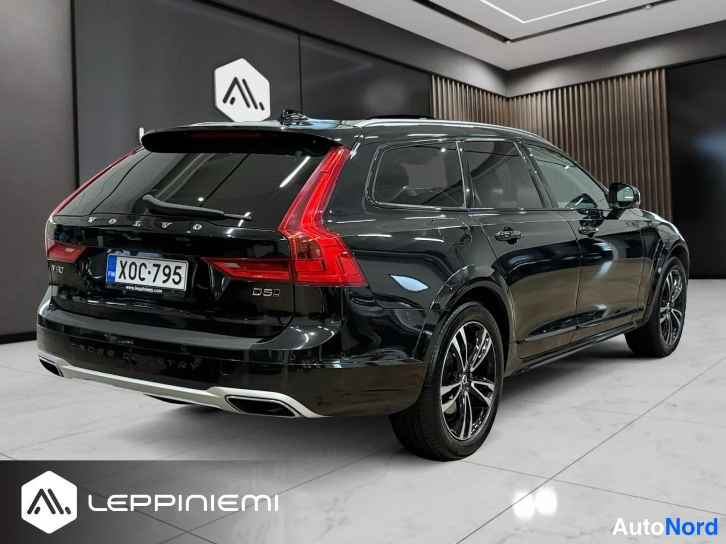Takaviisto: Musta Volvo V90 Cross Country farmariauto takaa-vasemmalta kuvattuna, D5-merkintä, rekisterikilpi, mustat kevytmetallivanteet.