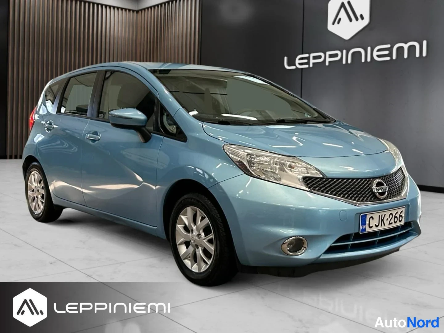 Etuviisto, nokka oikealle: Sininen Nissan Note etu-Sivukulmassa, rekisterikilpi näkyvissä