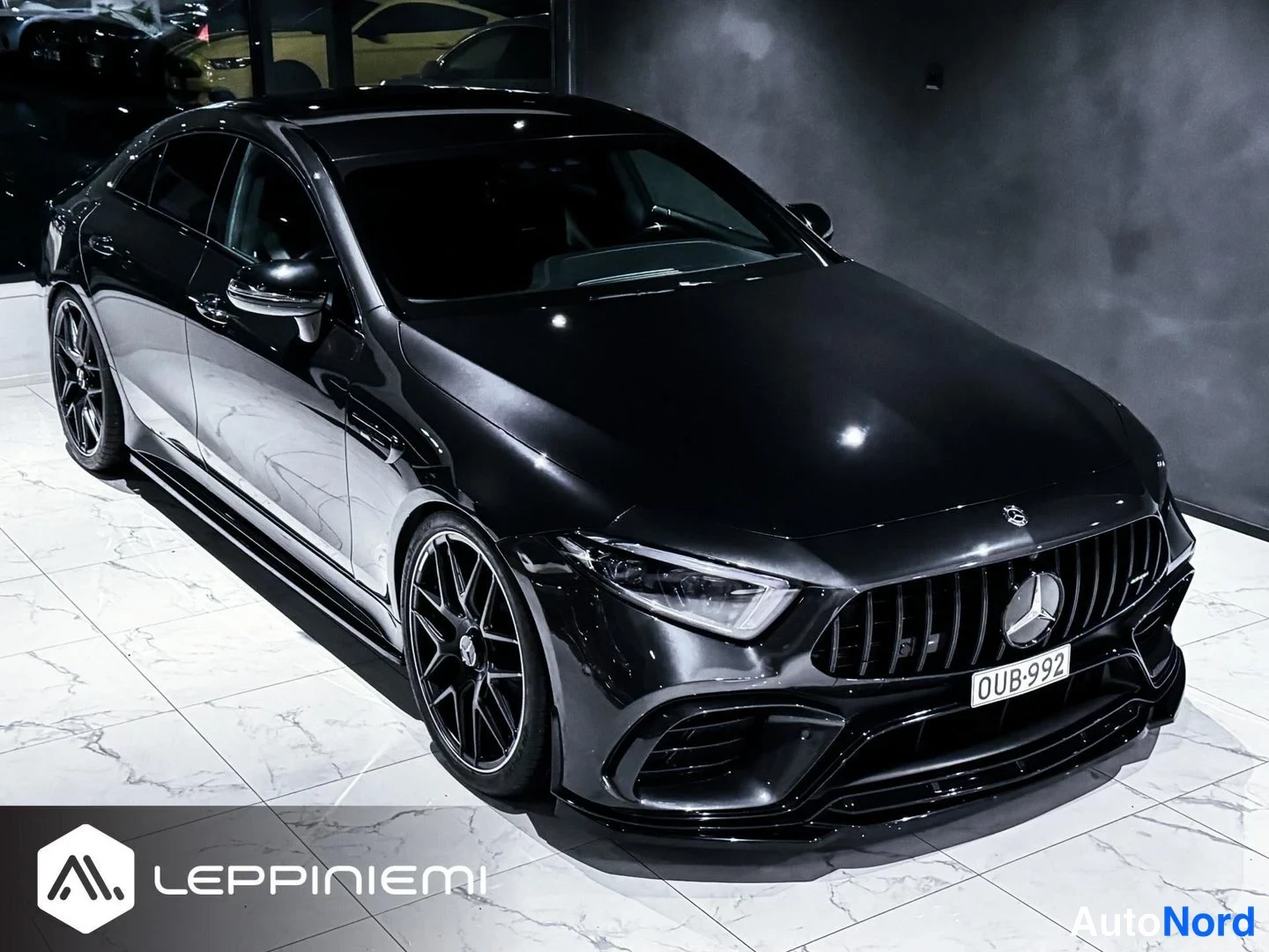 Etuviisto, nokka oikealle: Yläviistosta kuvattu musta Mercedes-Benz CLS -coupe etukulmasta oikealta, mustat AMG-vanteet, rekisterikilpi.