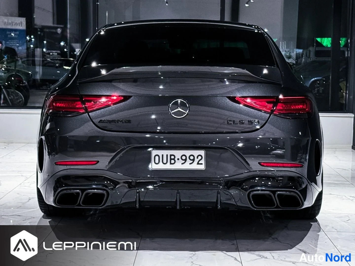 Takaa: Tummanharmaa Mercedes-Benz CLS suoraan takaa, näkyvät takavalot, AMG- ja CLS 53 -merkit, -rekisterikilpi ja neljä pakoputkea.