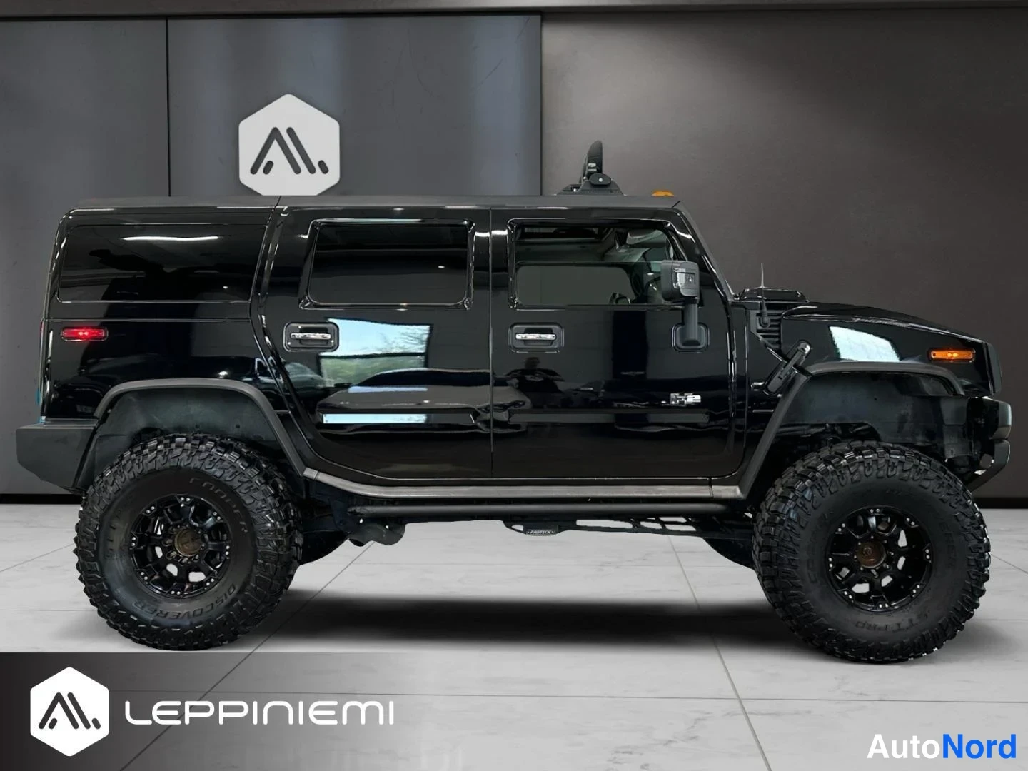 Sivulta: Mustan Hummer H2:n sivukuva; auton kylki ja neljä ovea näkyvissä, suuret maastorenkaat ja kylkiin asennetut sivukaaret.