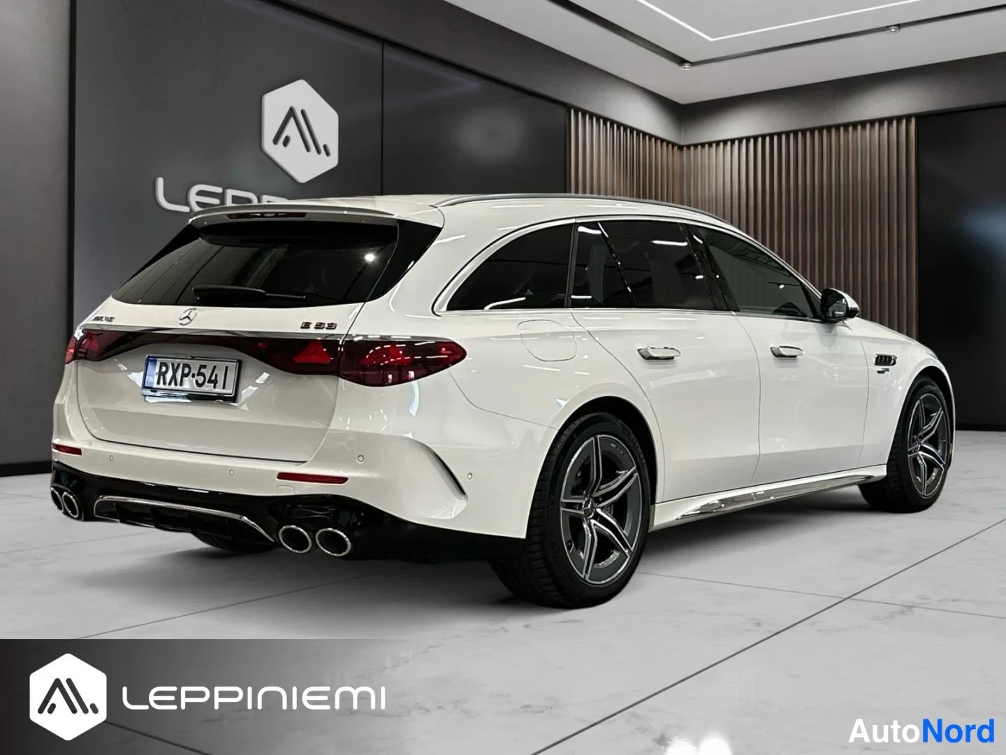 Takaviisto: Valkoinen Mercedes-Benz E 53 -farmariauto takaa ja sivulta nähtynä, rekisteritunnus.