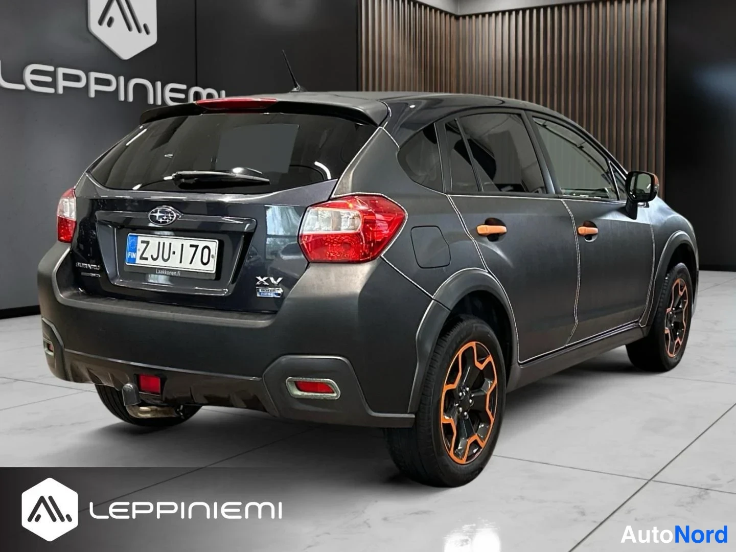 Takaviisto: Subaru XV:n takakulma kolmesta neljäsosasta vasemmalta, rekisteritunnus, tumma kori ja takarenkaissa oranssit vanteet.