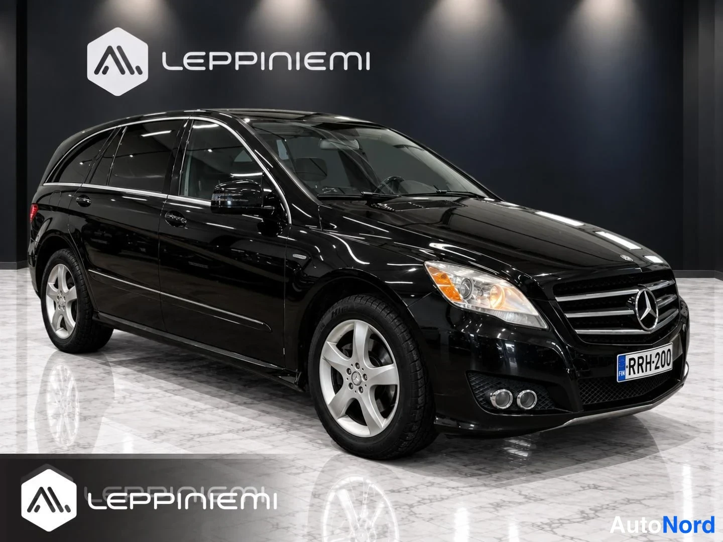 Etuviisto, nokka oikealle: Mustan Mercedes-Benz R -mallin etukulmanosto oikealta, rekisteritunnus, hopeiset viisipuutankkoratteet.