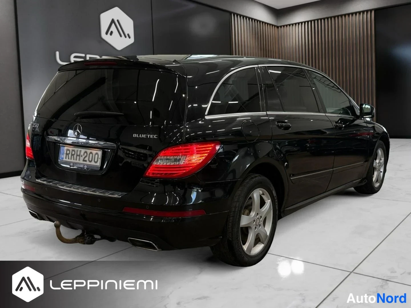 Takaviisto: Mercedes-Benz R:n takakulma vasemmalta: musta koripelti, takavalot, -rekisteritunnus ja BlueTec-teksti näkyvät.