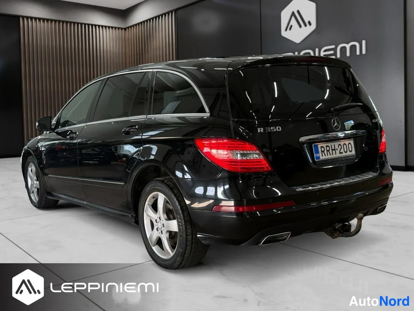 Takaviisto: Mercedes-Benz R:n takakulma oikealta: musta koripelti, takavalot, R 350 -merkintä, -rekisteritunnus ja vetokoulu.