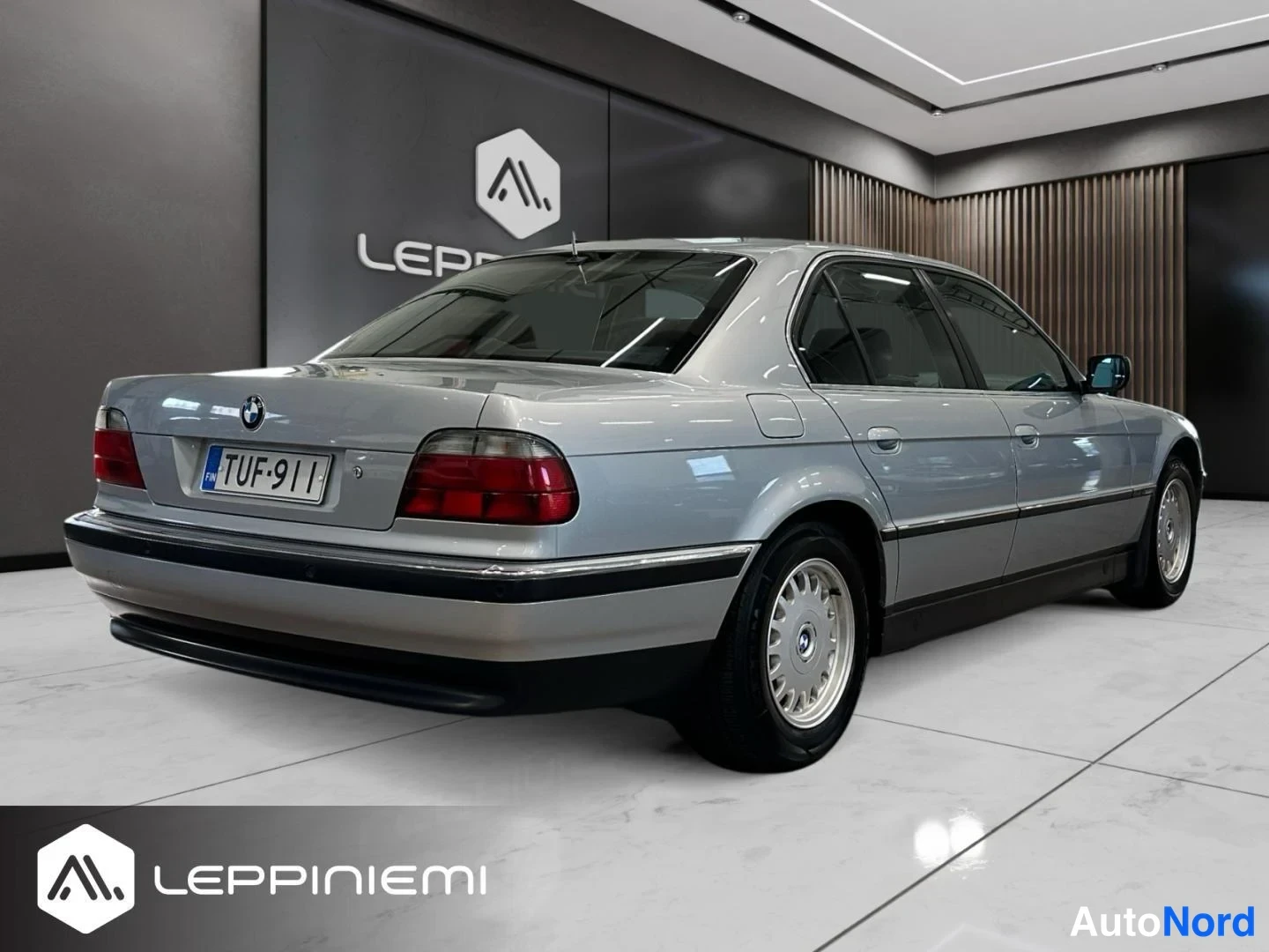 Takaviisto: BMW 735 -sedan takakulmanäkymä sisätiloissa, rekisteritunnus.