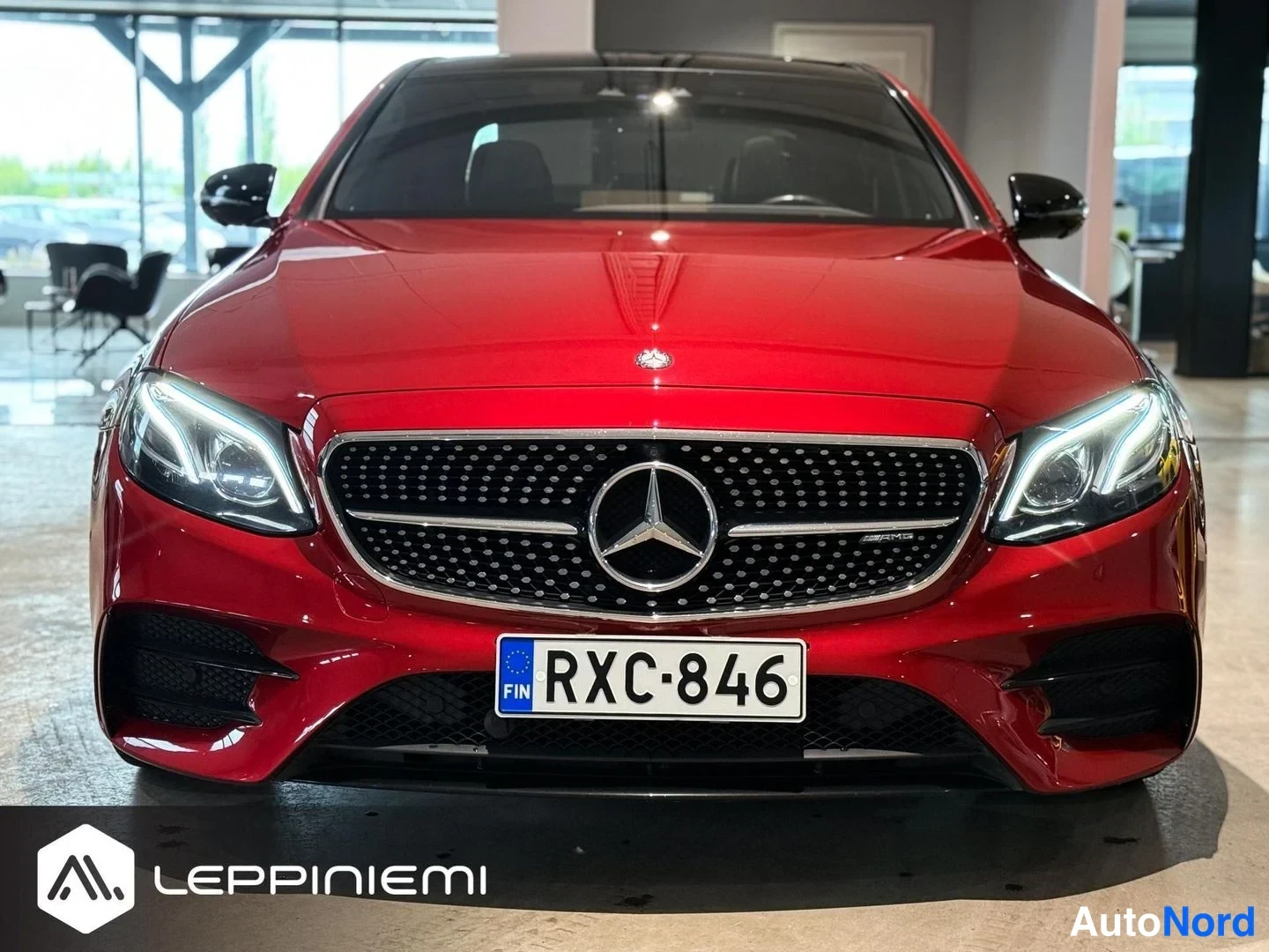 Edestä: Punaisen Mercedes-henkilöauton etunäkö, rekisteritunnus, AMG-merkintä etusäleikössä.