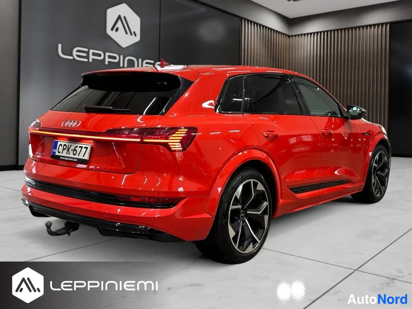 Takaviisto: Punainen Audi e-tron takaa katsottuna sisätiloissa, rekisterikilpi.