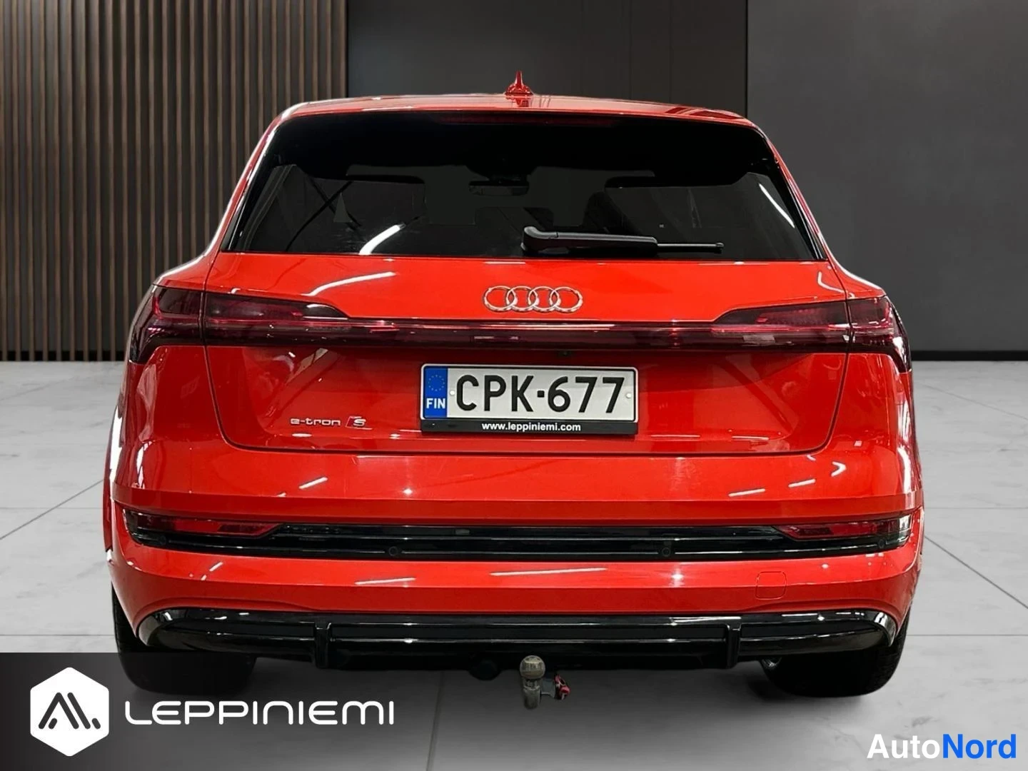 Takaa: Audi e-tron S:n takaa näkyvä punainen auto rekisterillä, vetokoulu näkyvissä.
